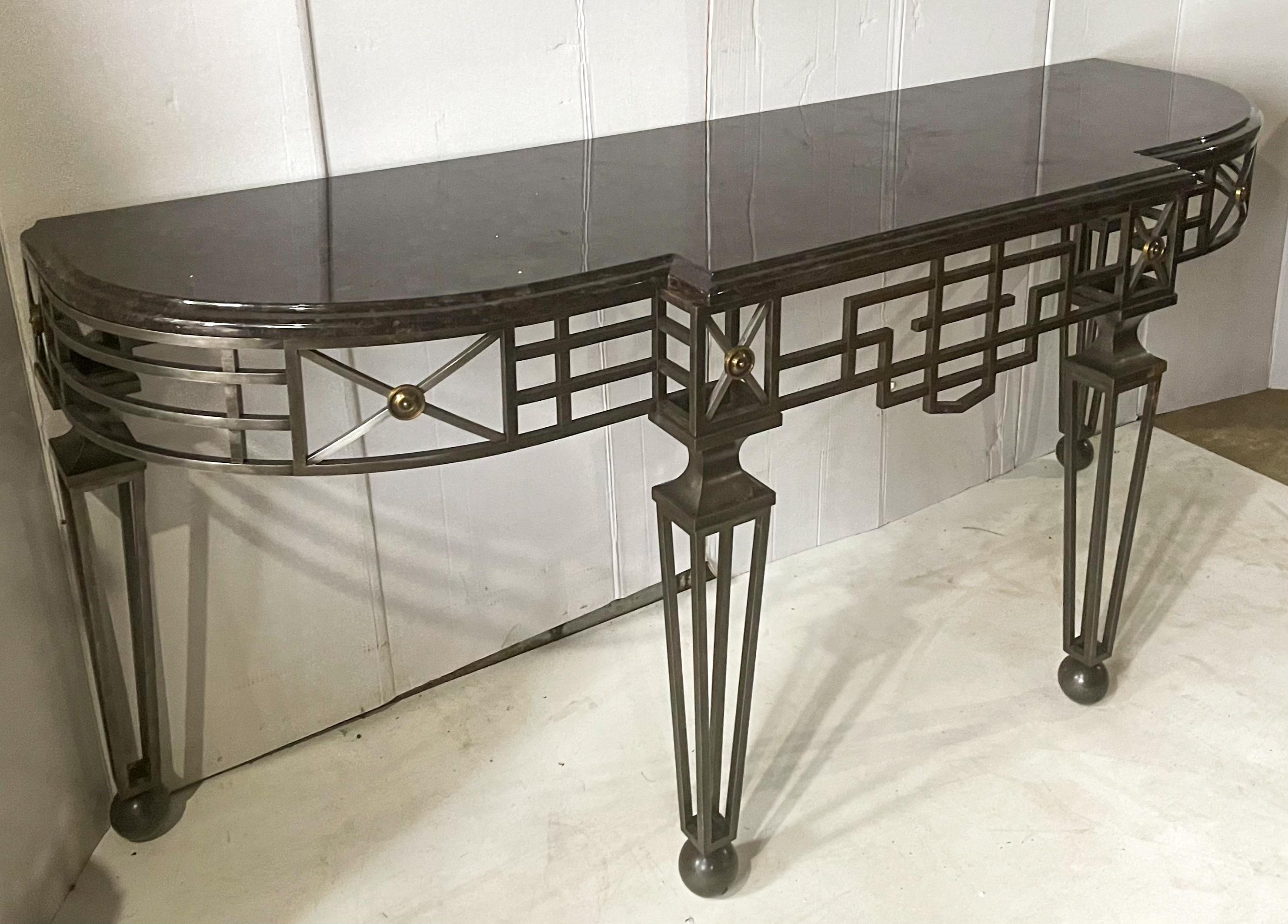 This is a late 20th century Italian neo-classical style iron, brass and granite console table. There are two available. The granite is a tone on tone black with a beveled edge. They are unmarked and in excellent condition. Additional discounts