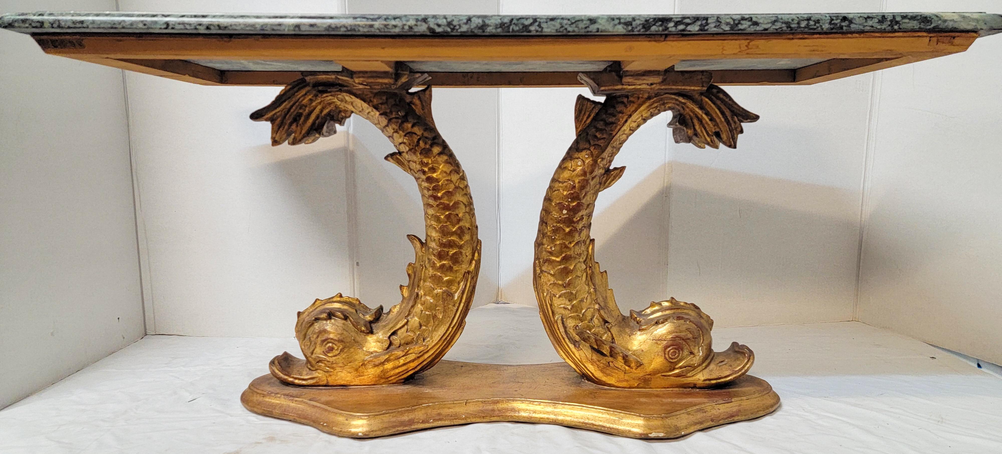 This is a wonderful neo-classical style carved giltwood koi fish coffee table or bench with a green veined marble top. The giltwood frame is marked and in very good condition. The piece dates to the 1960s. Thereis a larger available as well.