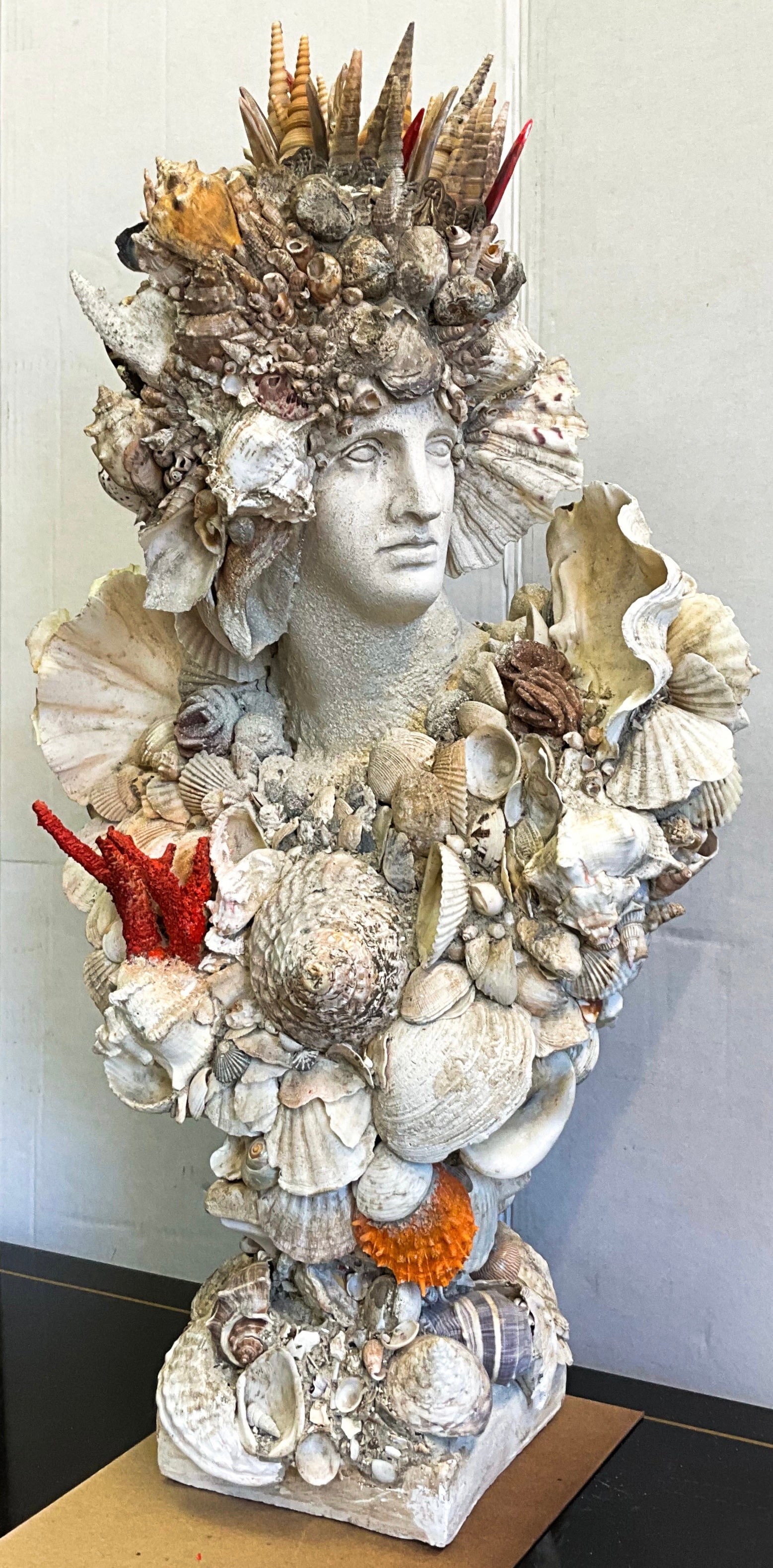 This is such a beautiful piece! This is a Greco-Roman cast plaster bust that has been encrusted in an array of amazing shells. I do not know who the artist is but it is magic! The base is 6.25 inches square. It is in very good condition.
