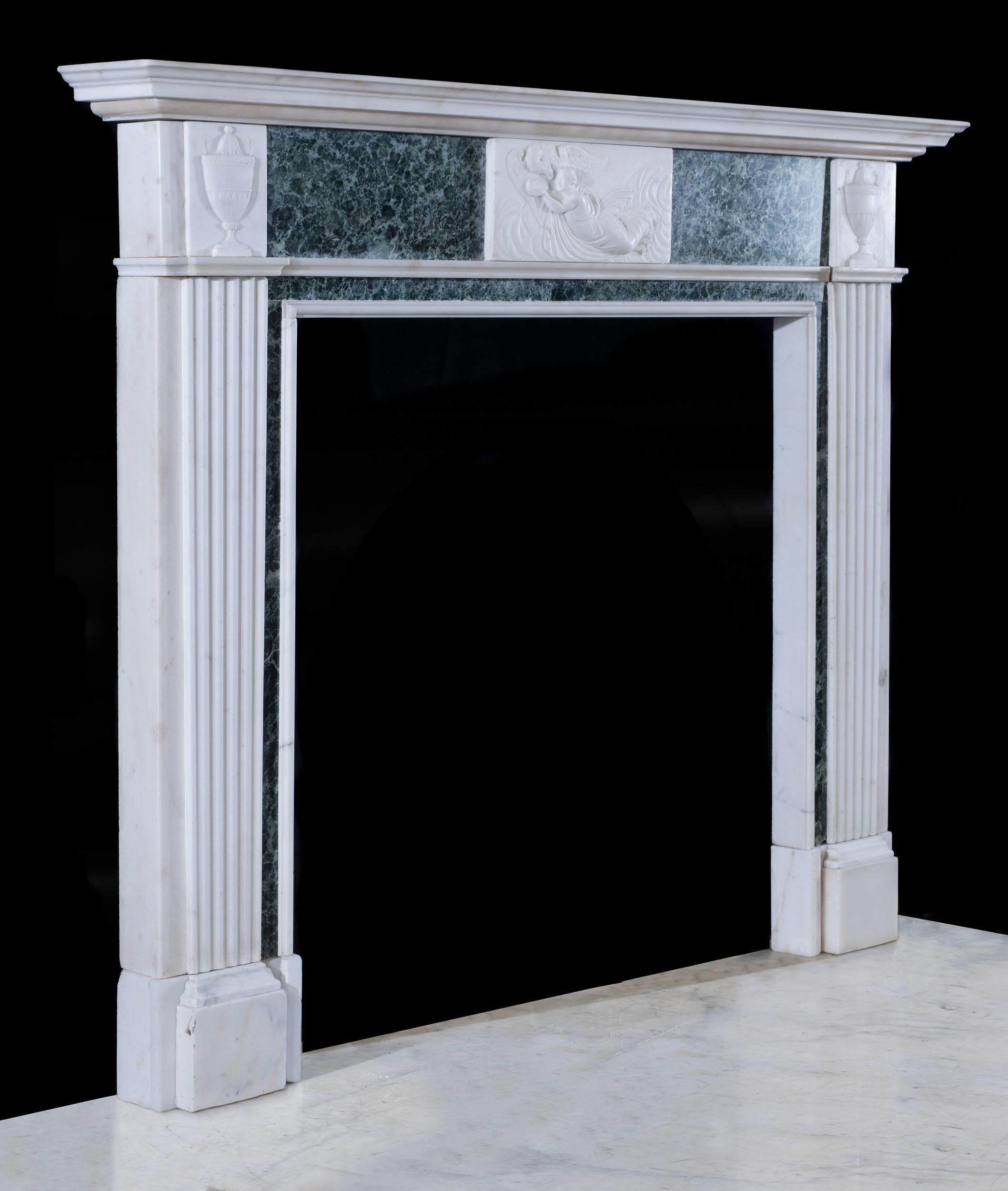 An antique neo-classical white statuary marble fireplace with Verde Antico ingrounds and frieze panels centred by a carved central tablet depicting Hebe in classical robes feeding Jupiter in the form of an eagle among clouds. This is flanked by a