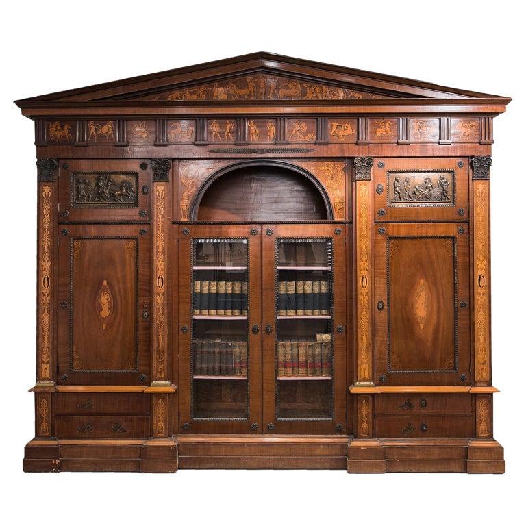 Neo-classicist furniture ensemble for personal office space.
The set formed part of a bishop's heritage, who had left it to the Hungarian Church.
The monumental bookcase is decorated with wooden inlay depicting scenes of ancient ink drawings. The
