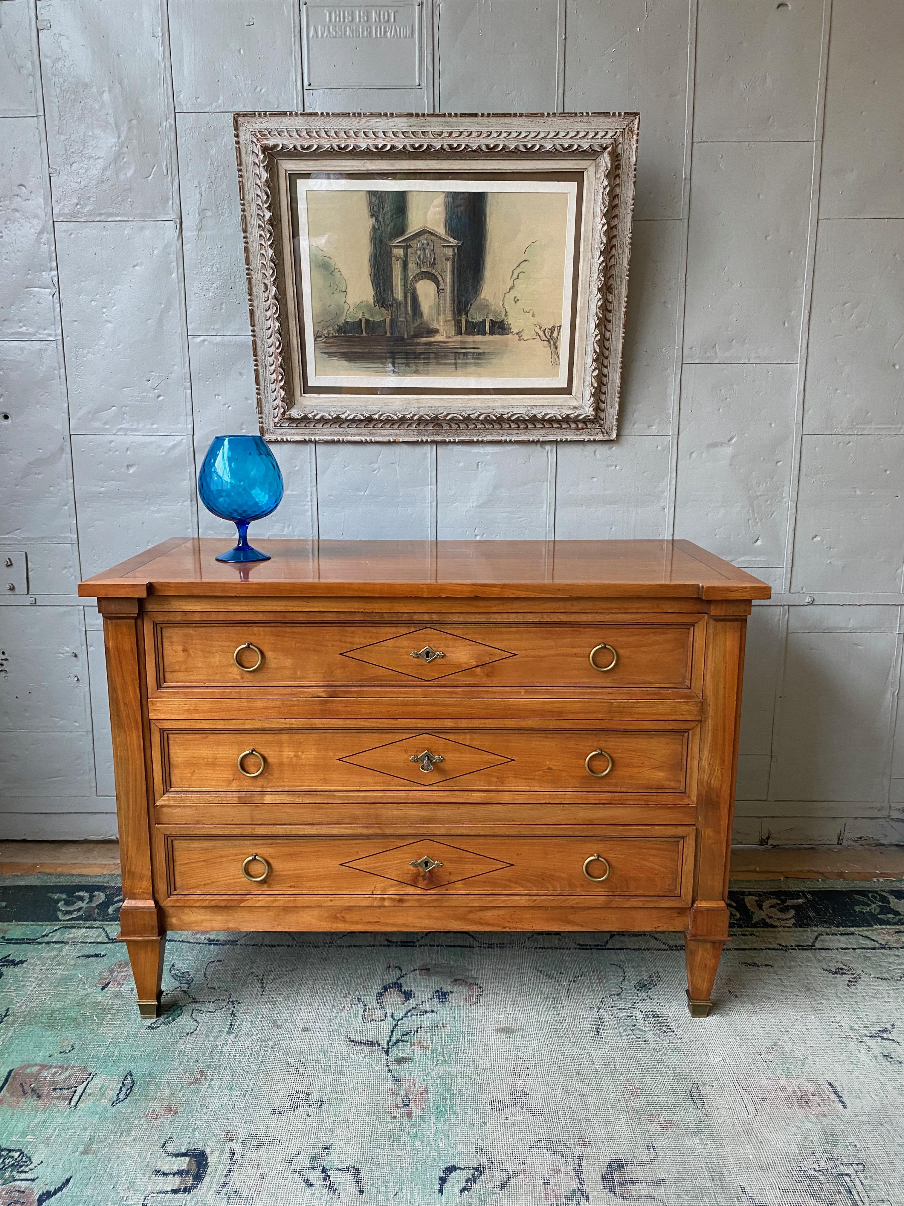 Bellissima cassettiera a tre cassetti in stile Directoire francese degli anni '40 in legno di frutta chiaro con intarsi in legno scuro a contrasto. In ottime condizioni d'epoca, è stato lucidato di recente e presenta la ferramenta e i sabot