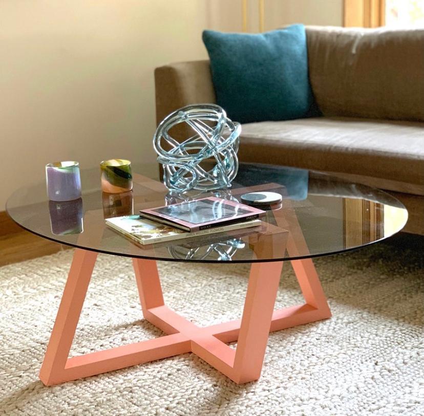 Trapezoidal forms in rich colorways interconnect in a dance of inverted symmetry beneath the smokey glass oval top.  Every view of this piece is different as you travel around the room, creating a standout centerpiece for the sitting room or living