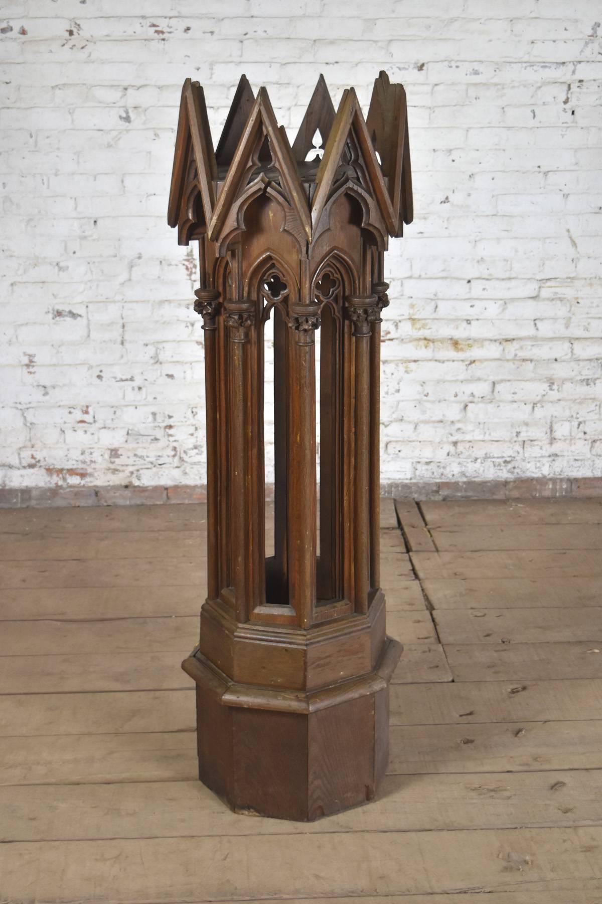 An unusual pedestal of octagonal Neo-Gothic form, the molded base supporting eight shaped and carved columns decorated with typical Gothic designs, topped by eight spikes surrounding an inset platform. Height of platform inside top-spires: 50.5