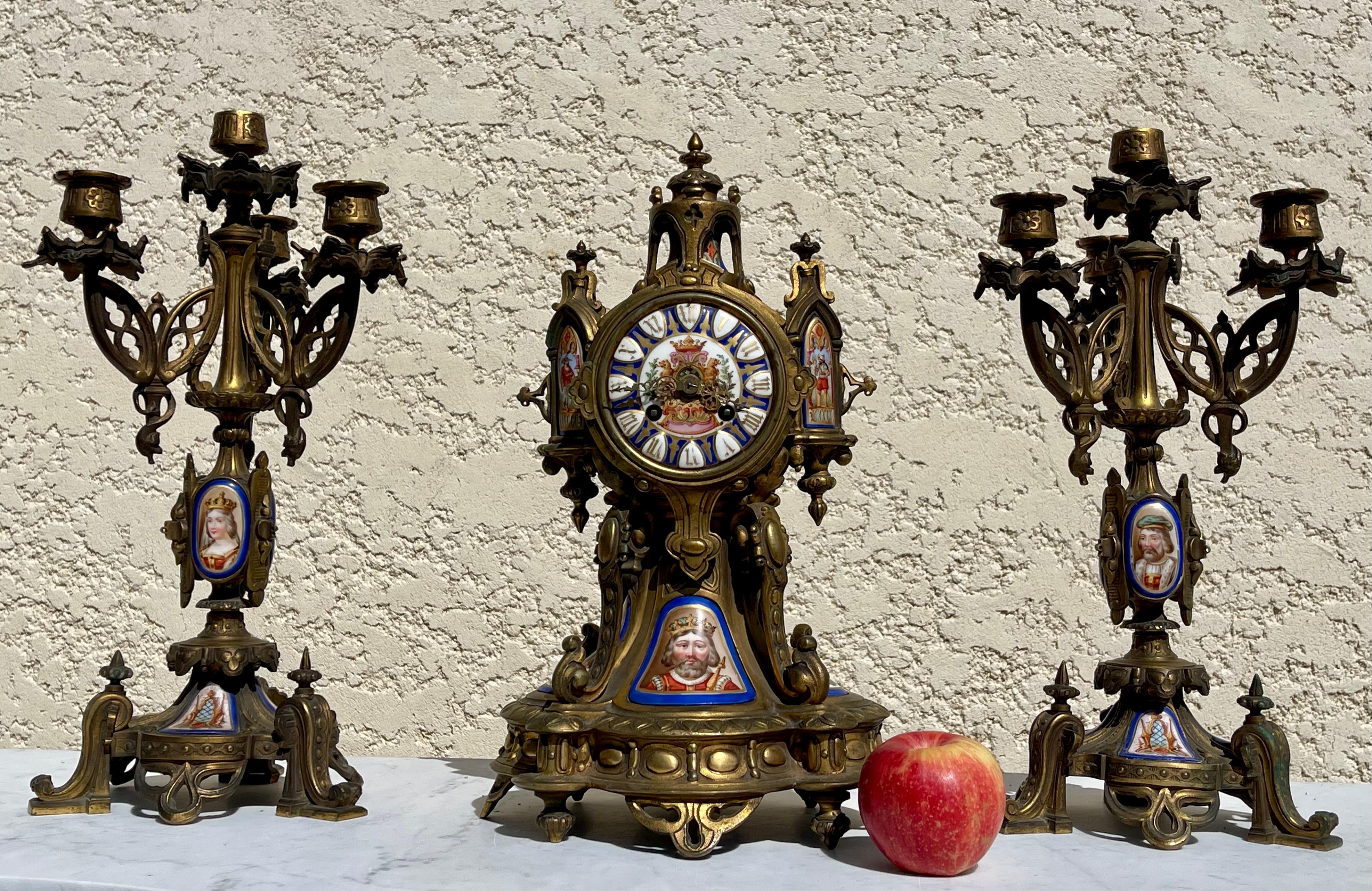 Neo-Gothic style gilt bronze fireplace insert with painted porcelain medallions. There are three different medallions on the candelabra and two different medallions on the pendulum. All in good condition.