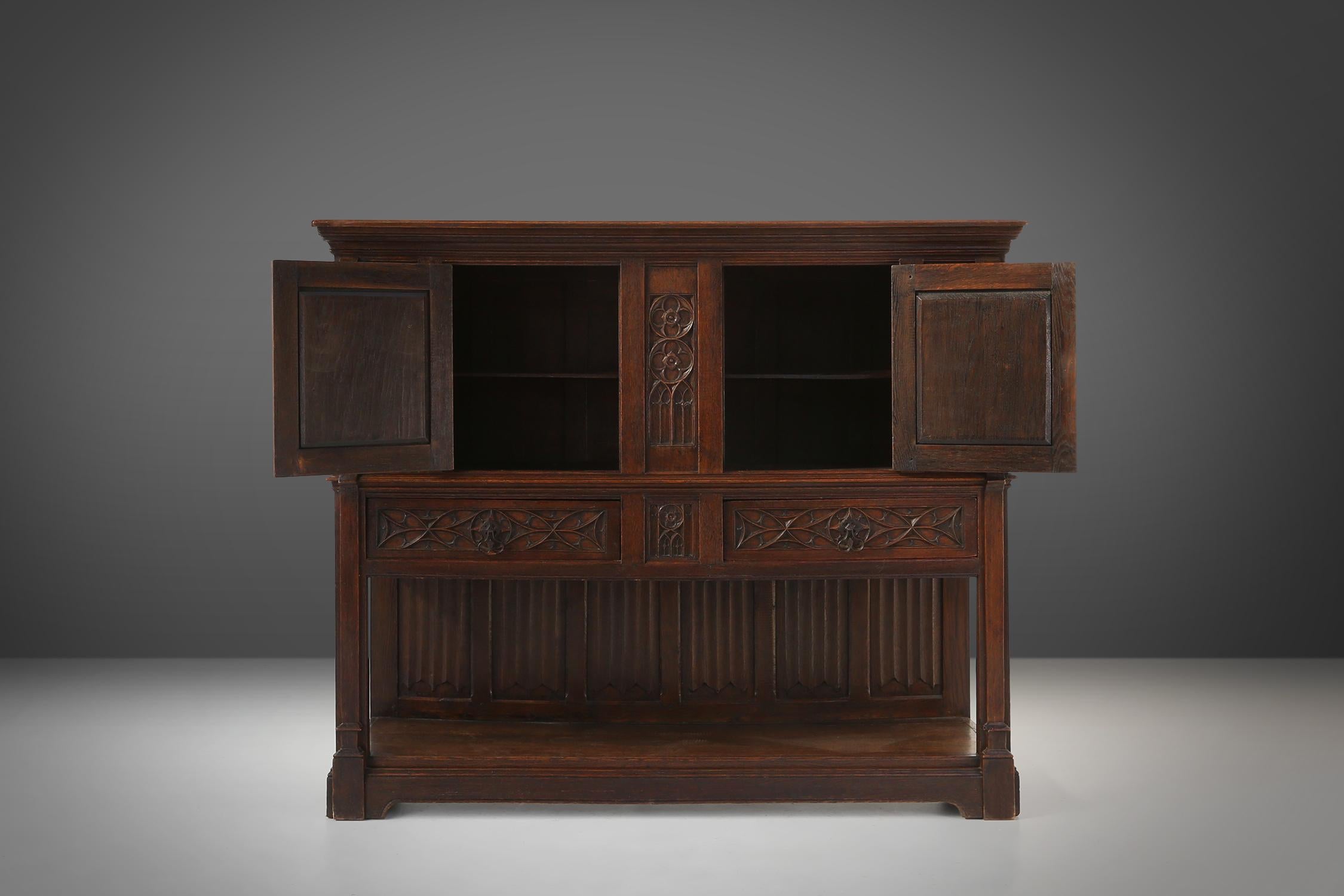 French Neo-gothic cabinet in oak with rich decorations and hidden storage, France, 1850 For Sale