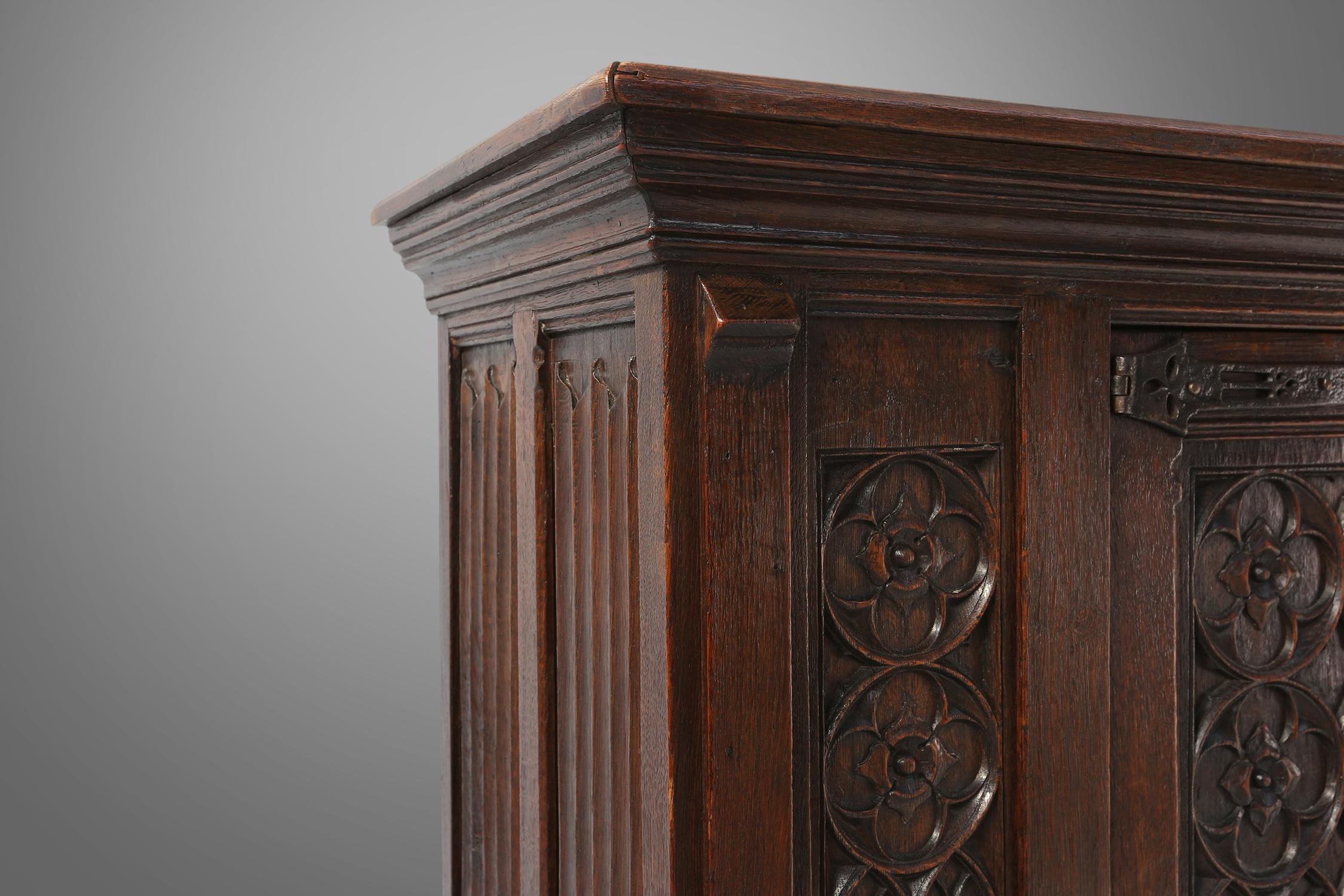 Wood Neo-gothic cabinet in oak with rich decorations and hidden storage, France, 1850 For Sale