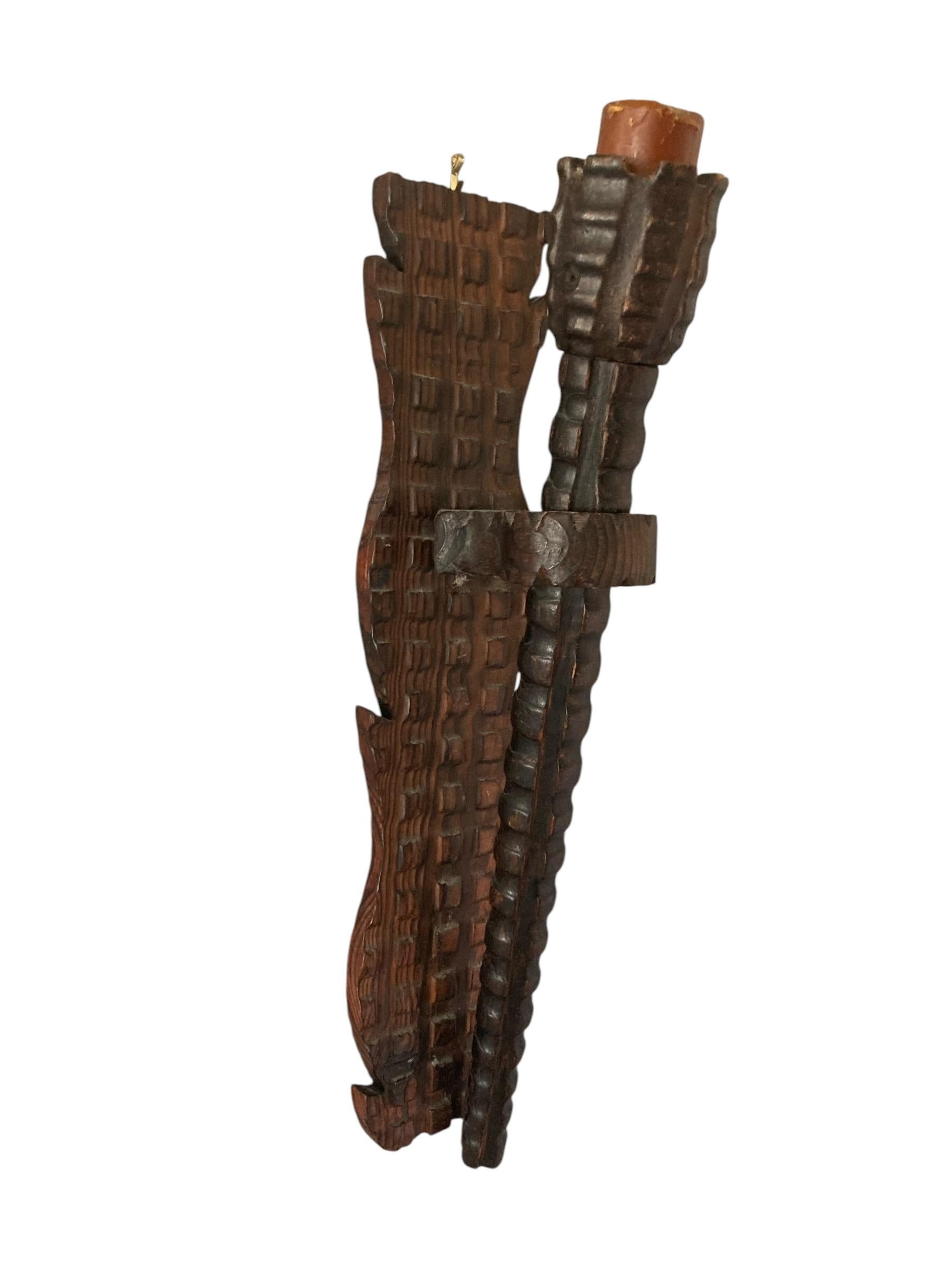 Bougeoir ou torchère mural en bois sculpté de style néo-gothique médiéval. Cet imposant bougeoir en bois allie harmonieusement beauté naturelle et fonctionnalité, avec un design robuste qui s'intègre à tous les décors. Le support accueille une