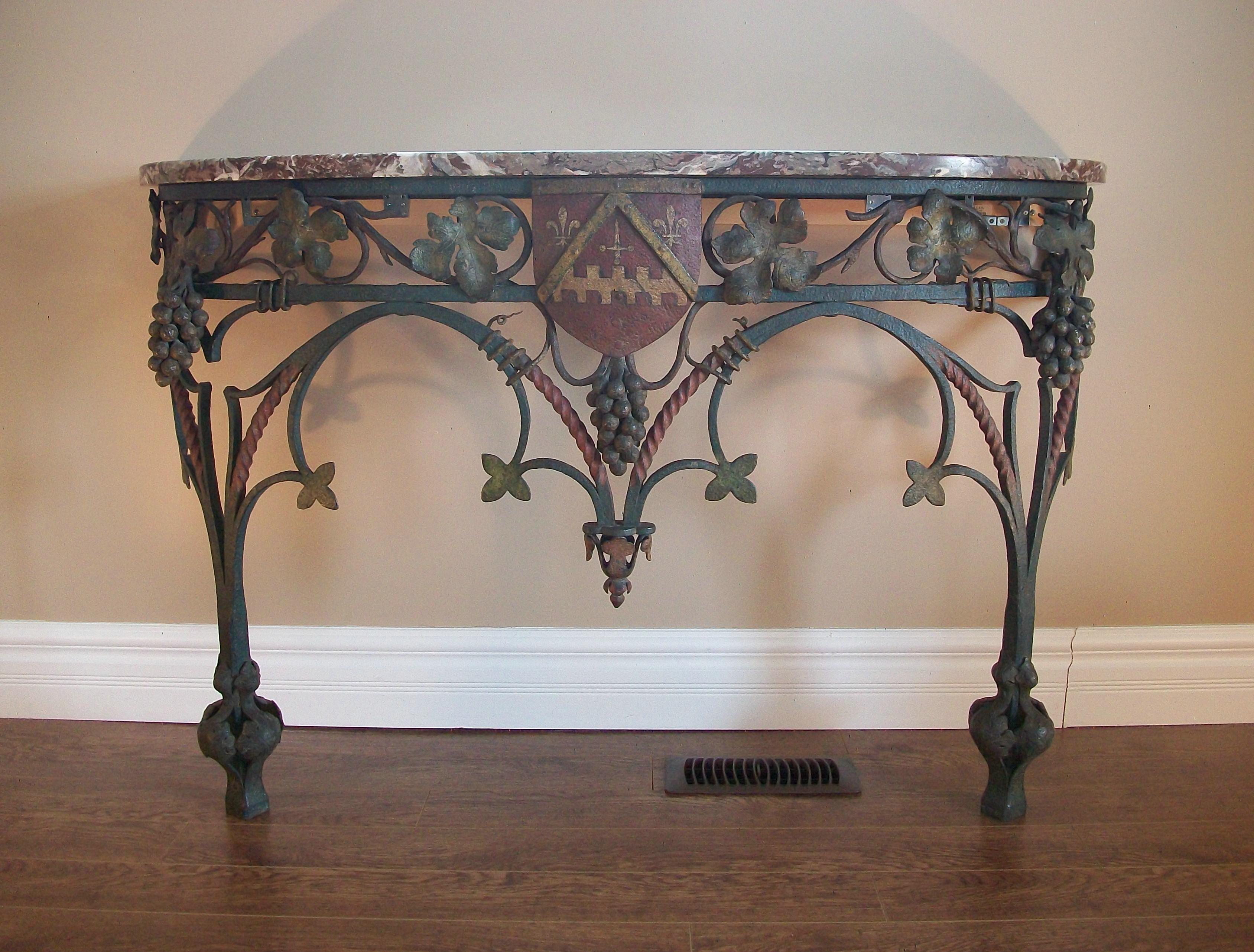 Exceptional and rare antique Neo Gothic wrought iron console table with family crest and original Rouge Royal marble top - riveted construction throughout - completely hand made - decorated with bunches of grapes (each grape individually hand