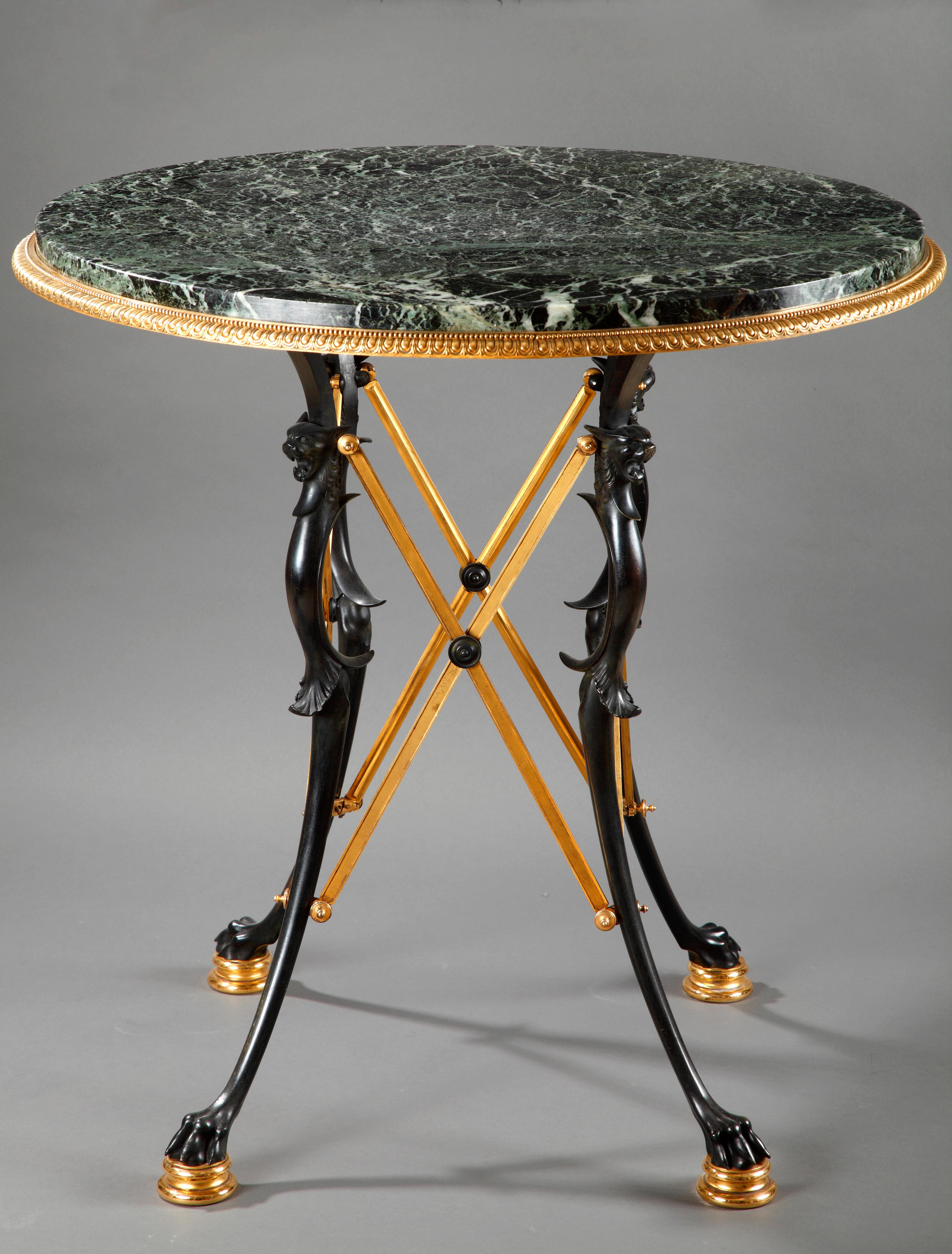 A similar model was exposed at the 1889 Paris Universal Exhibition ( see picture attached)

Patinated and gilded bronze gueridon with four paw feet joined by X-shaped stems, attributed to Sévin and Barbedienne. Round green marble top mounted with a
