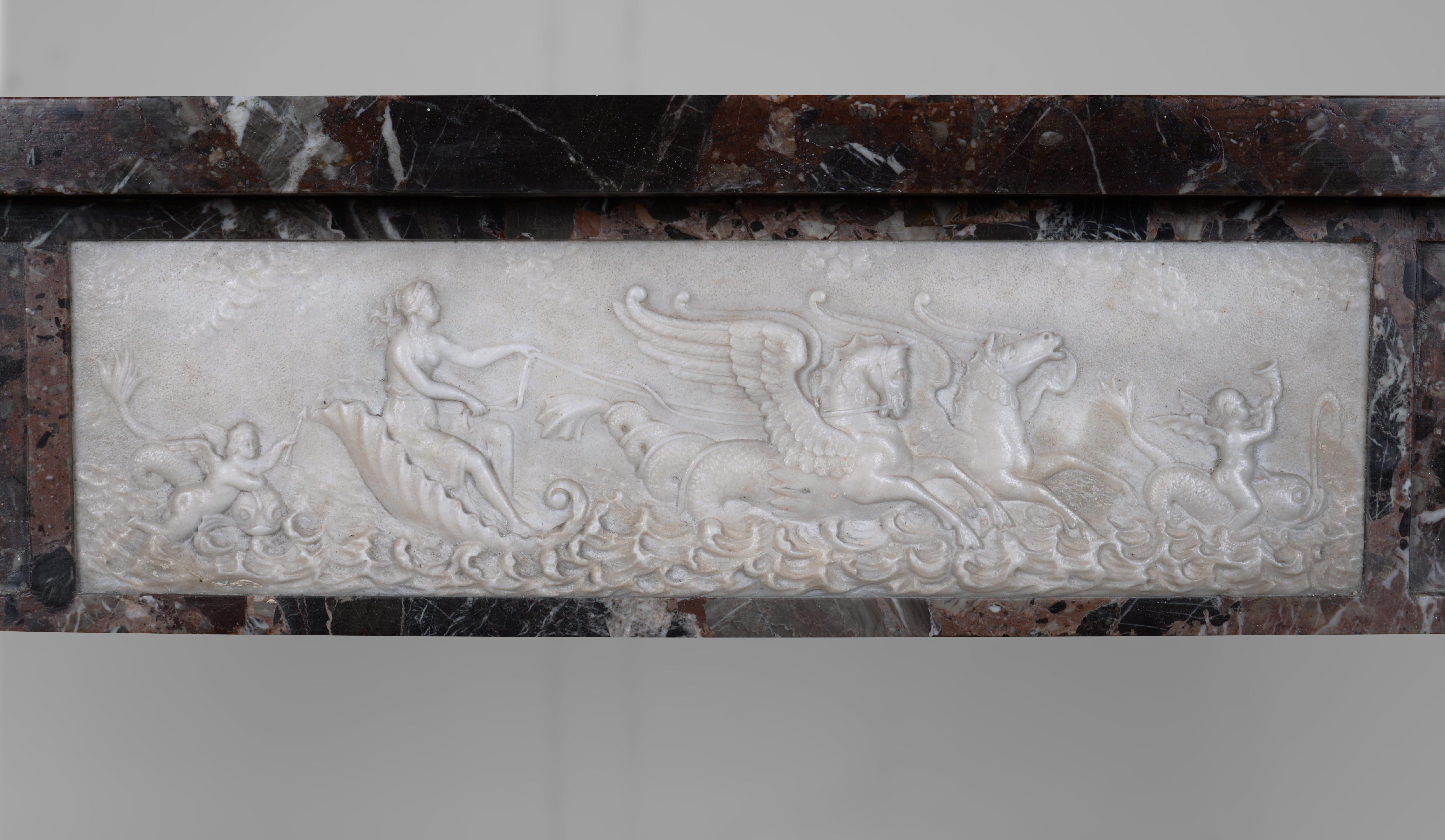 This neo Louis XVI style fireplace was sculpted in the 19th century in imperator and statuary marble. Its front part is decorated in its center with a frieze in statuary Carrara marble representing a woman in a chariot on the water pulled by two