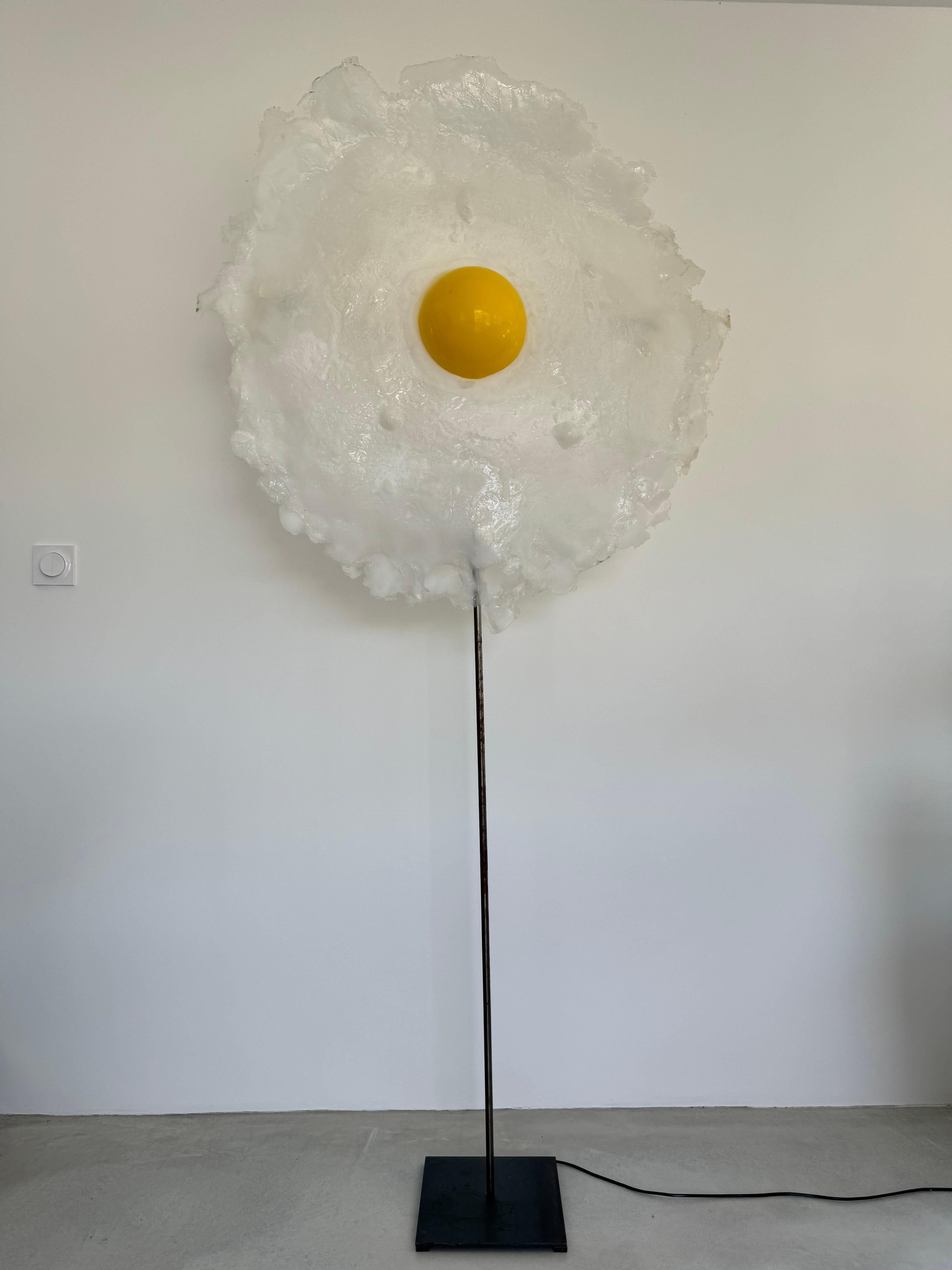 Énorme lampadaire ou sculpture lumineuse de l'artiste français Michel Froment ( 1951 ).

Reproduction d'un œuf au plat des deux côtés.

Les matériaux utilisés sont le métal et le polyuréthane.

L'œuvre de l'artiste est en bon état, quelques traces