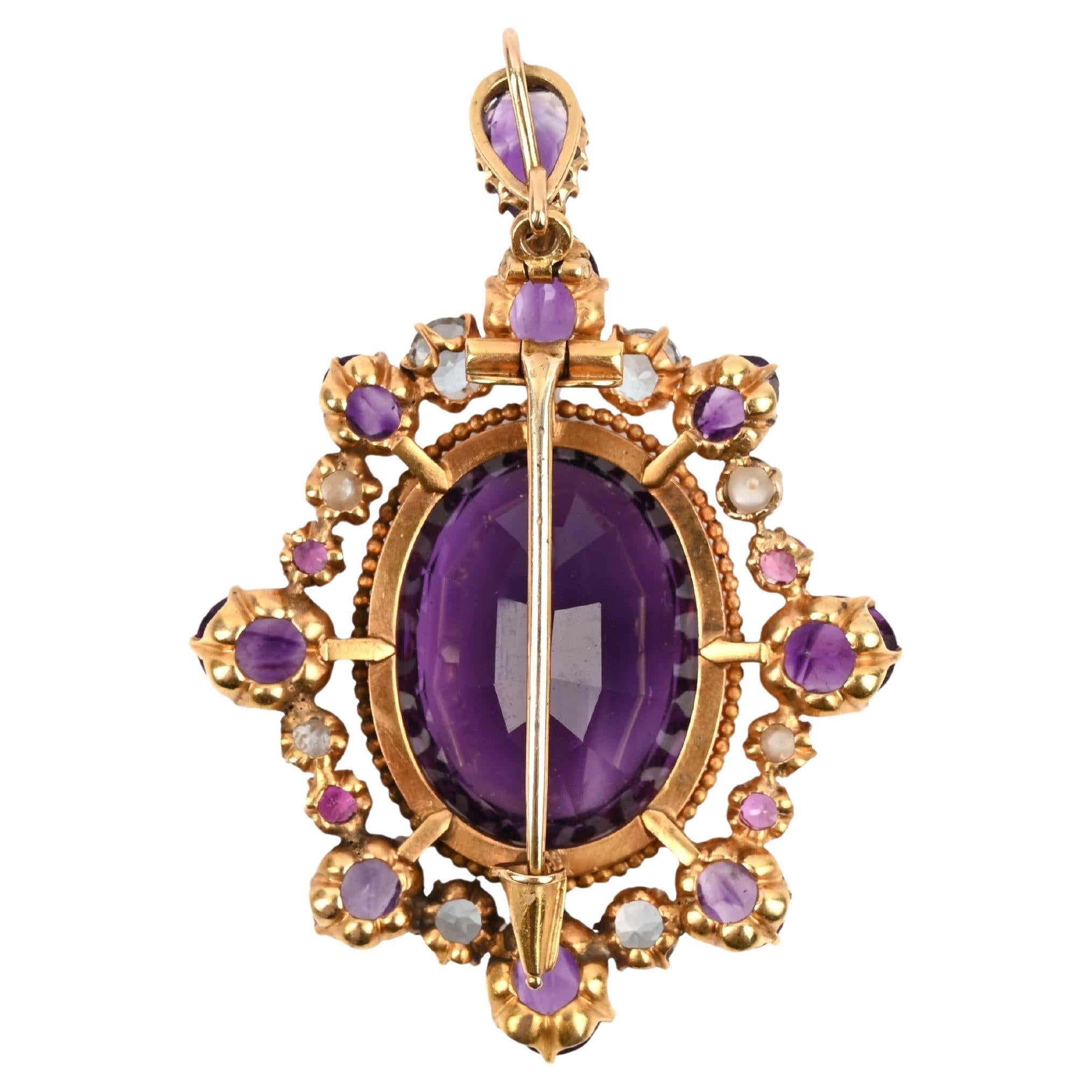 Spilla/pendente in ametista della metà del XIX secolo, con ametista centrale di forma ovale incastonata a griffe e circondata da ametiste graduate, acquamarine e perle in oro giallo, lunghezza 5,5 cm.
Peso: 23gr.