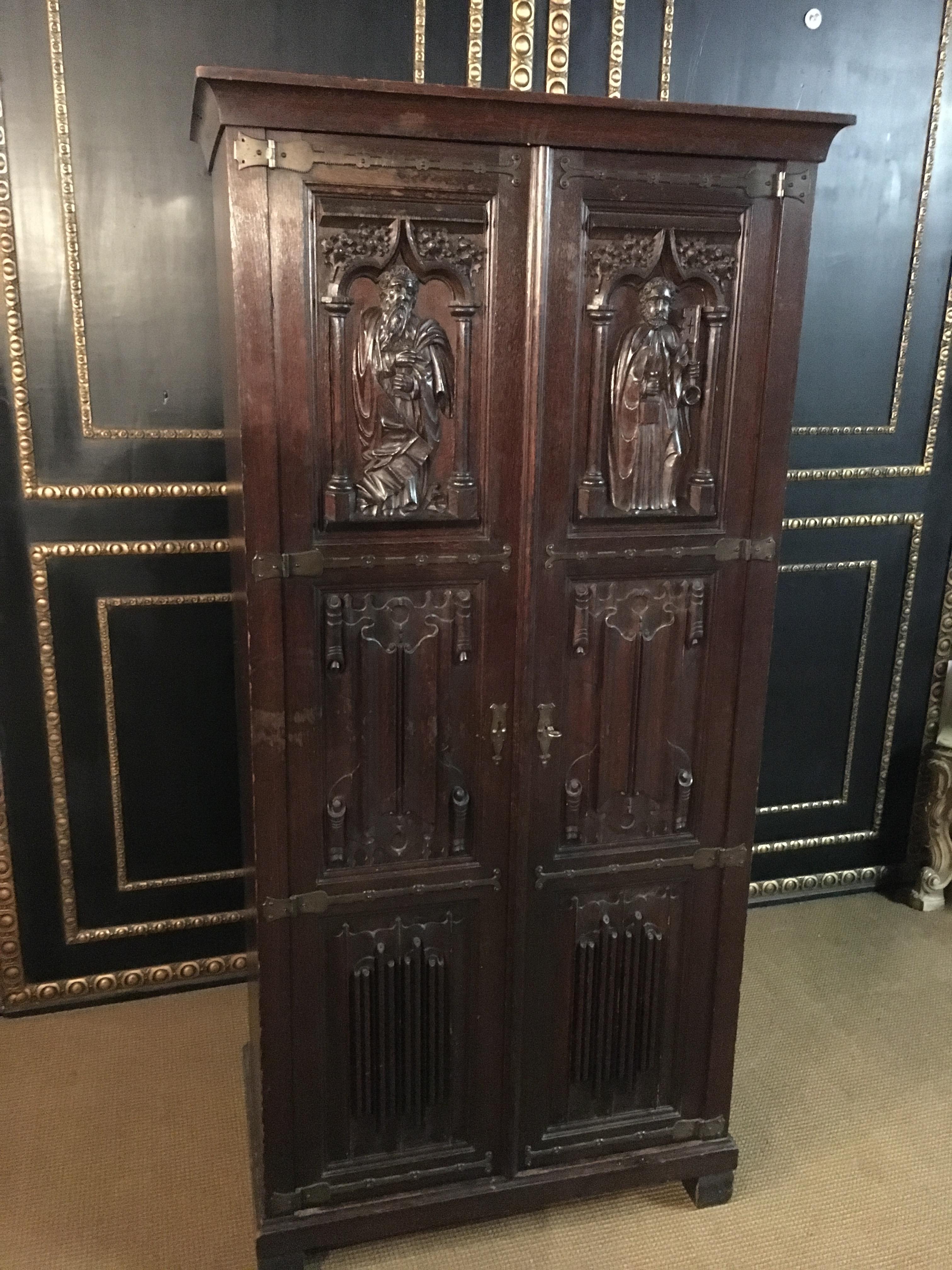 Solid oak with rich carving. Two doors.
High-quality carving with each right and left 1 figure fully carved.
The right figure has a key in his hand and the left figure 1 sword.
The doors are decorated with brass.