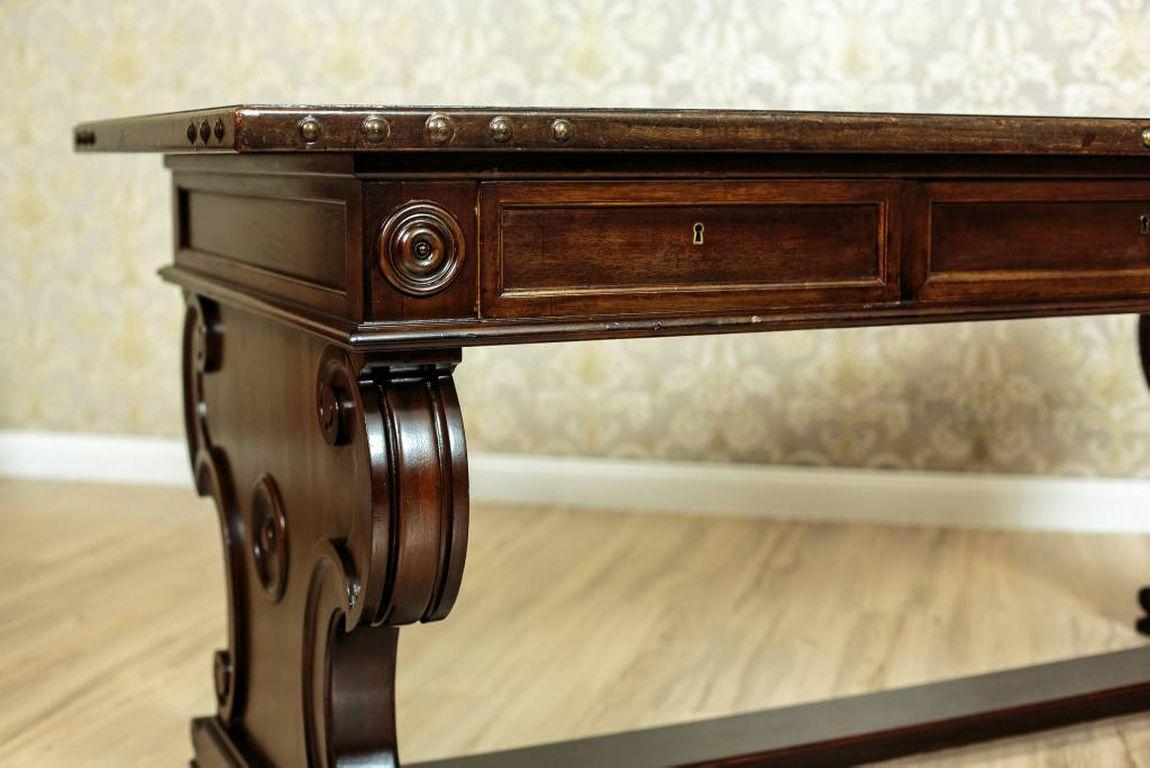 This desk, circa 1930, is made in oak. Its shape resembles the Italian furniture from the Renaissance period.

Simple, rectangular tabletop, supported by the sides in the shape of turned upside down scrolls. From the front, there are three