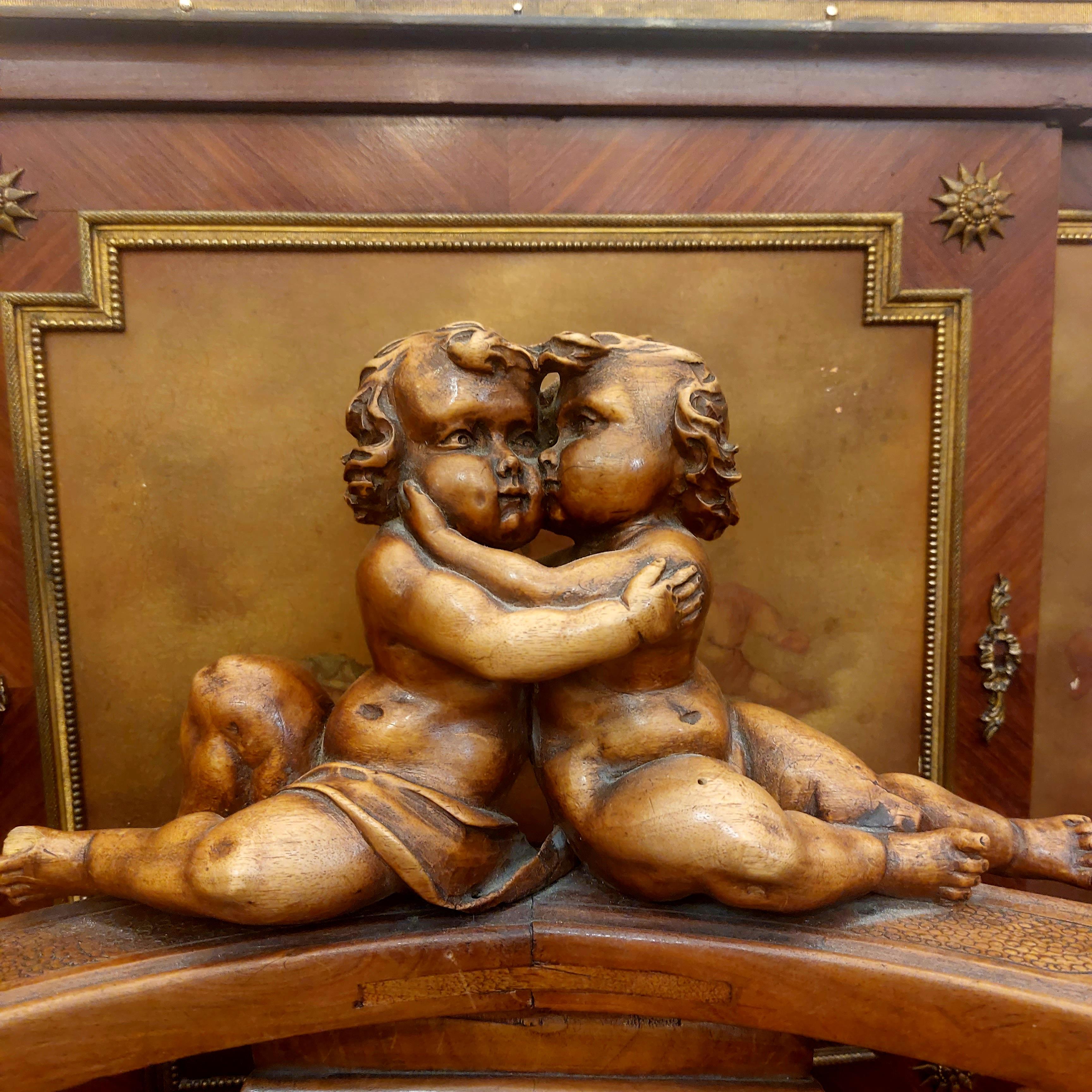 Élégant fauteuil italien en noyer richement sculpté surmonté de deux Putti enlacés et dont l'assise à été restaurée. Il est de style Louis XIII néo-Renaissance.

Très décoratif, très original et très riche de par l'impressionant de travail de