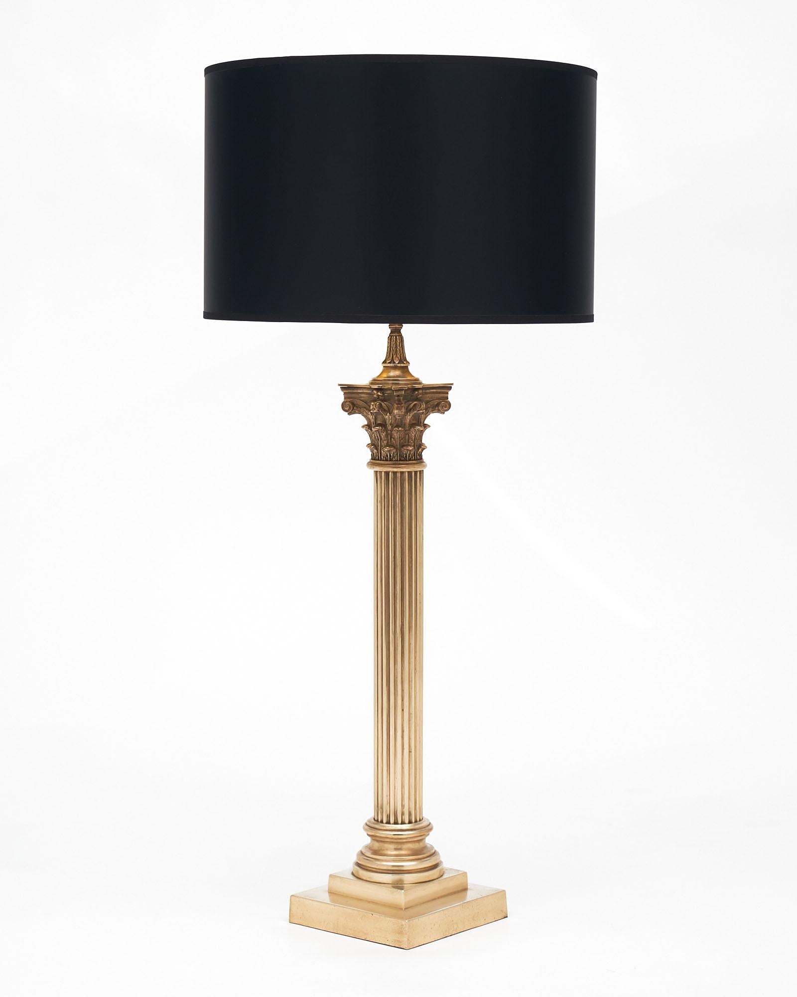 French Neoclassic brass lamp. This piece features a finely cast bronze ridged stem that rests on a gilt brass base.