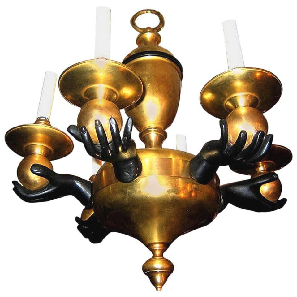 Lampadario francese a sei luci in bronzo con mani dorate e dipinte che reggono candelabri, circa anni '20.

Misure:
Altezza 24