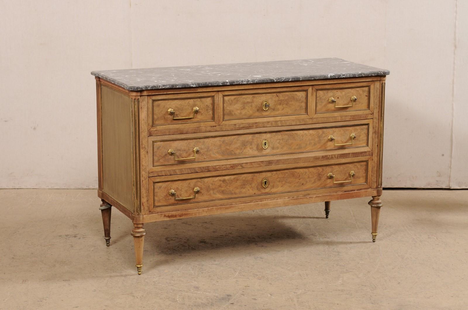 A French Neoclassical chest, with its original marble top and hardware, from the mid 19th century. This antique chest from France features a rectangular-shaped gray marble top with pronounced rounded front corners, which rests atop a neoclassical