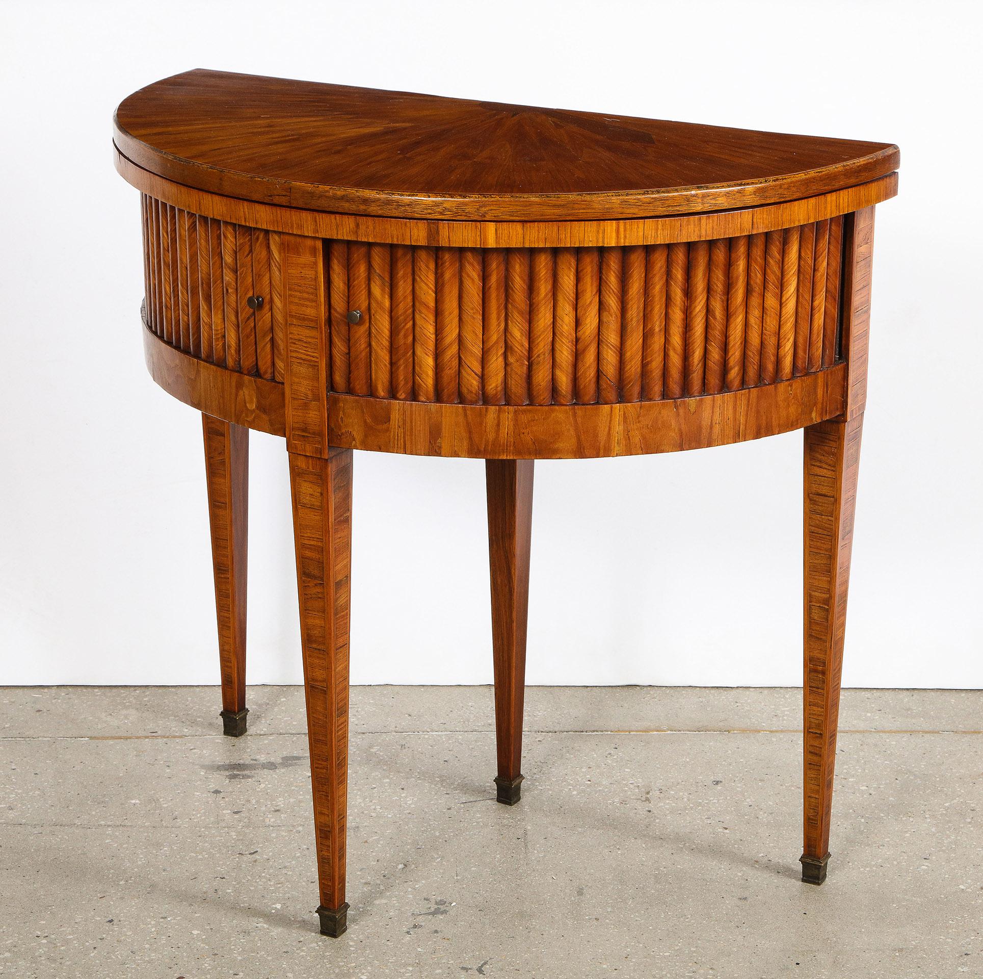 Tulip wood demilune game table

The tulip wood demilune table opening to a round felt lined playing surface, over matched tambour doors, over four tapered legs, the center back leg extending out to support the top when opened.