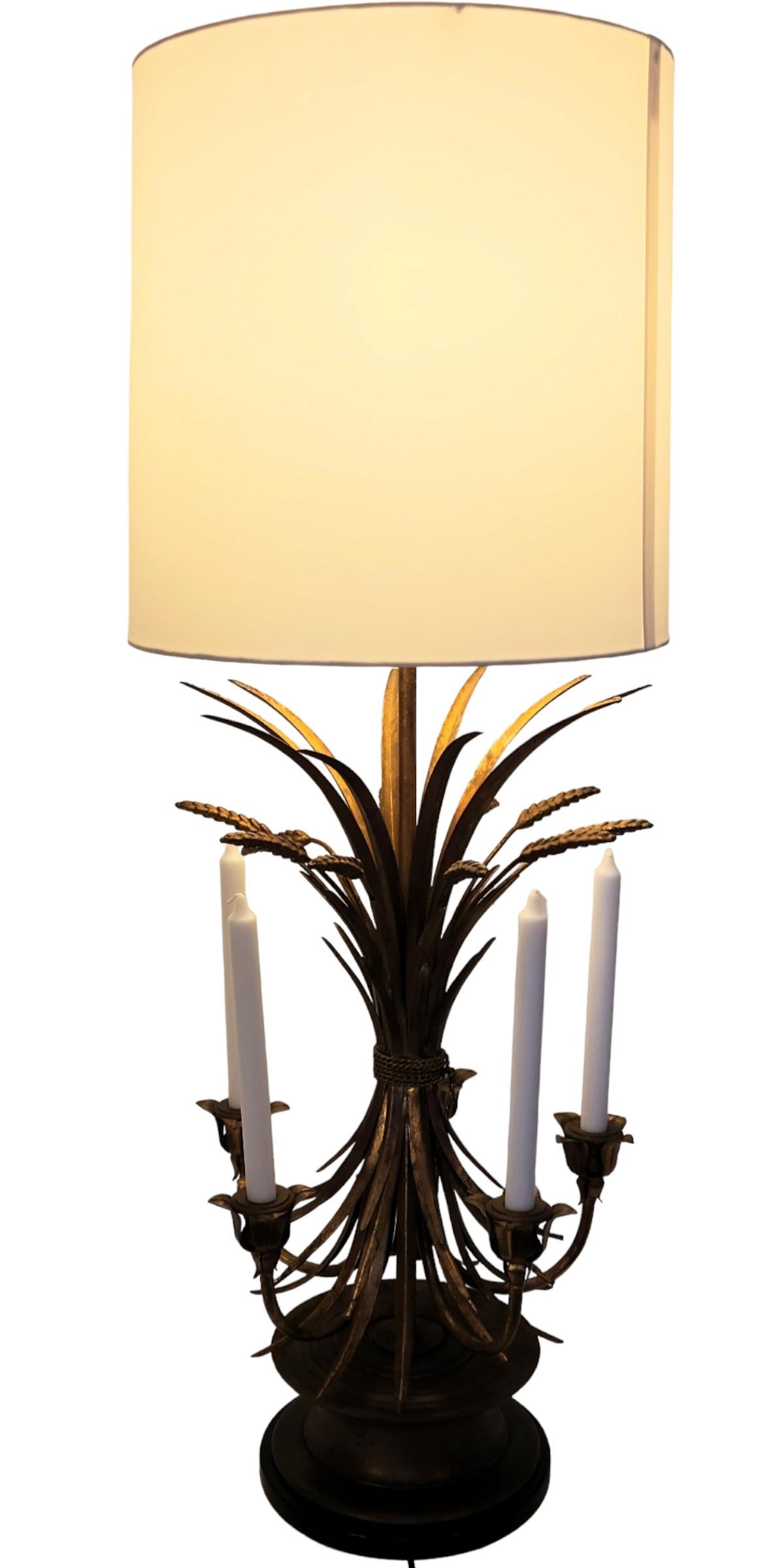 A neoclassic Italianate gilt sheaf of wheat five candle table lamp by Frederick Cooper from the late 1950s-early 1960s. 
The gilt metal body is mounted on a turned wooden spool base set on a black metal base.
The lamp has been professionally rewired