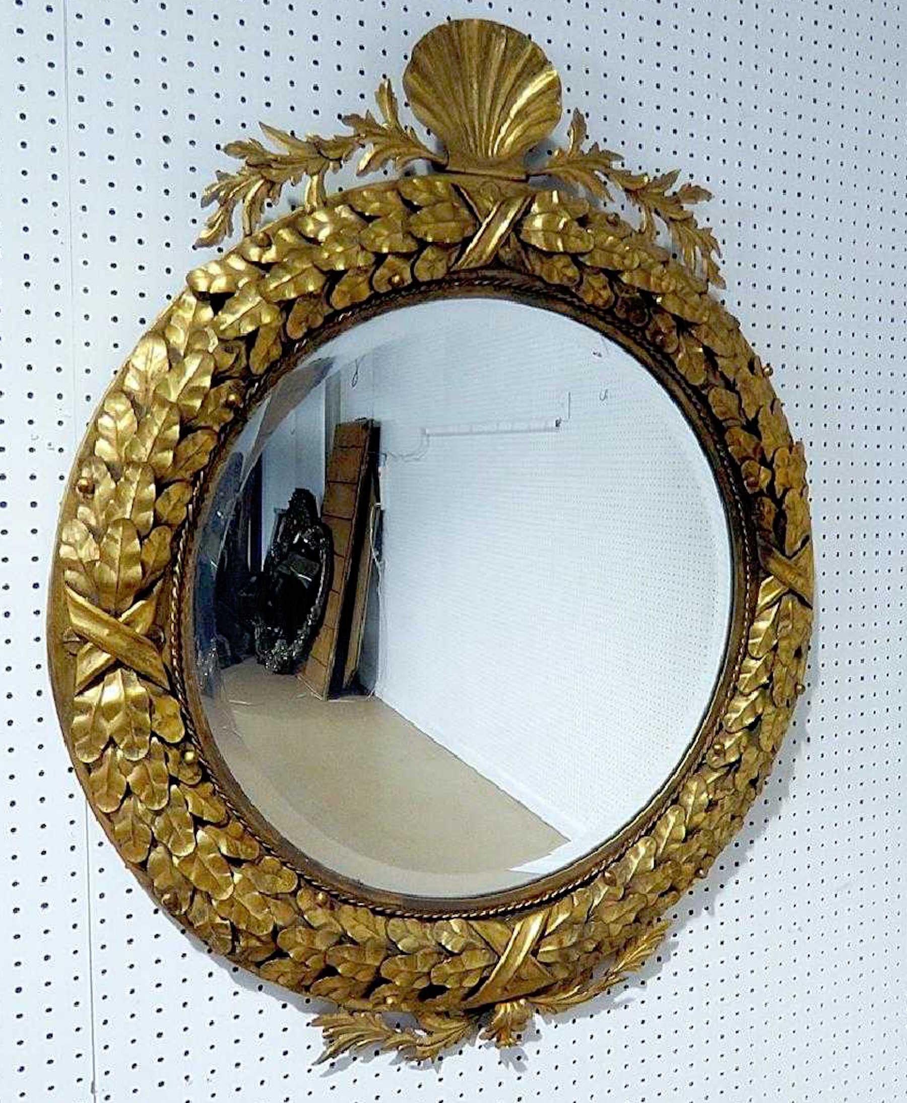 Neoclassic gilt tole shell motif mirror, in the Regency style of circular form with shell and wreath surround.