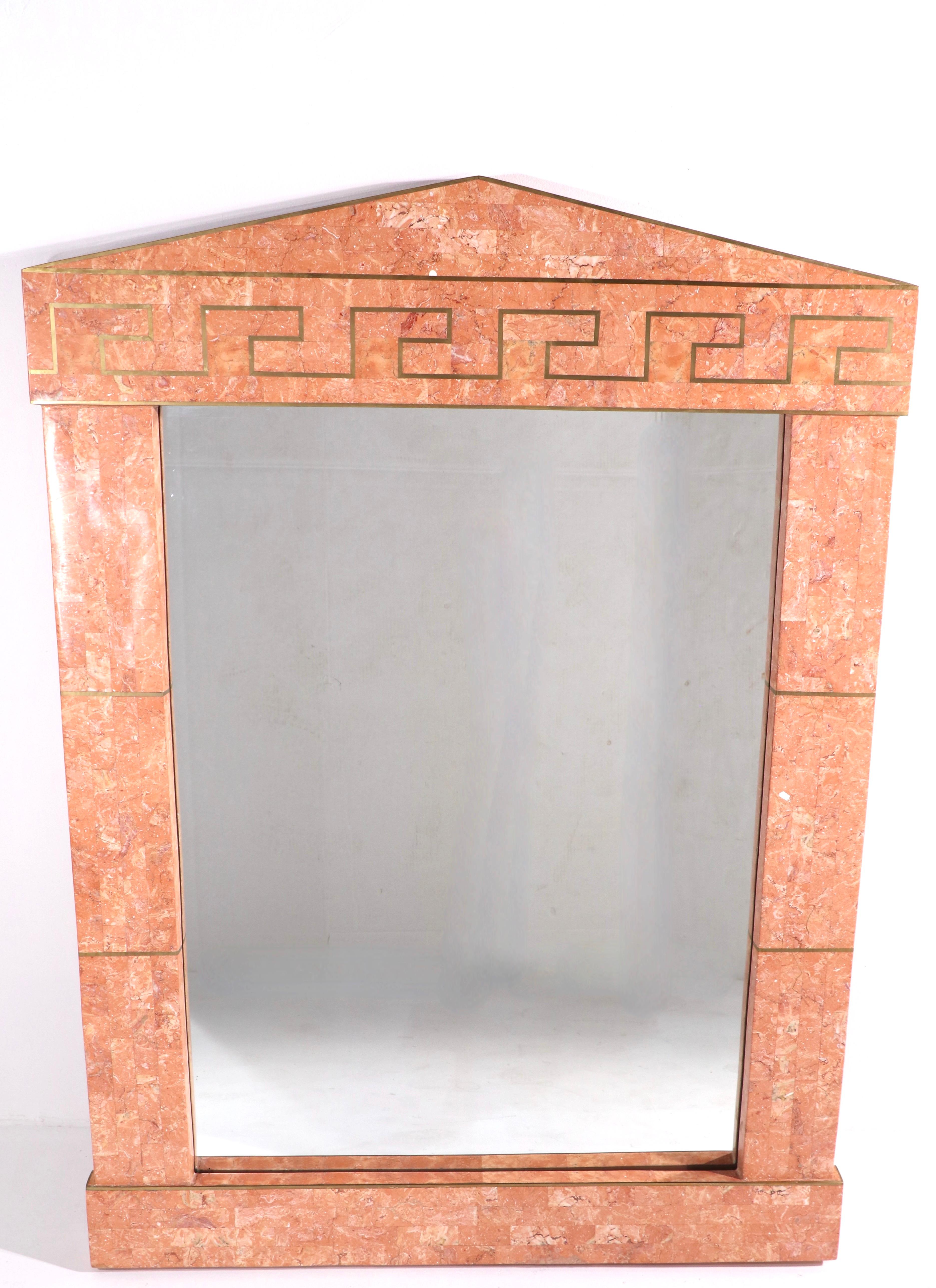 Stylish tessellated stone and brass string inly mirror by Maitland Smith. The frame has an architectural peaked top, over a rectangular inset mirror. It is in very Fine, original, clean and ready to install condition - this chic 1970's Art Deco