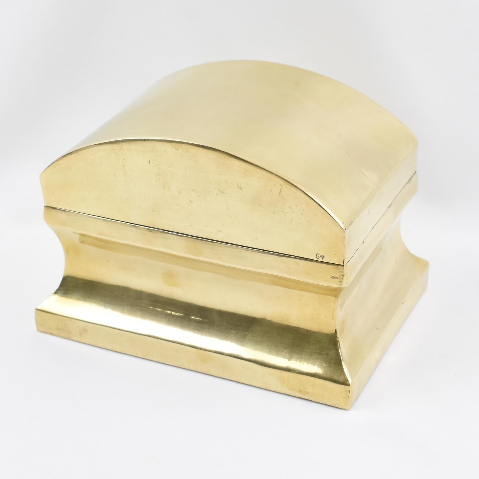 This stylish neoclassical modernist decorative lidded box or tea caddy boasts a rectangular shape with a streamlined design. The piece features polished brass metal with a hinged domed lid shaped like an urn. There is no visible maker's mark, but