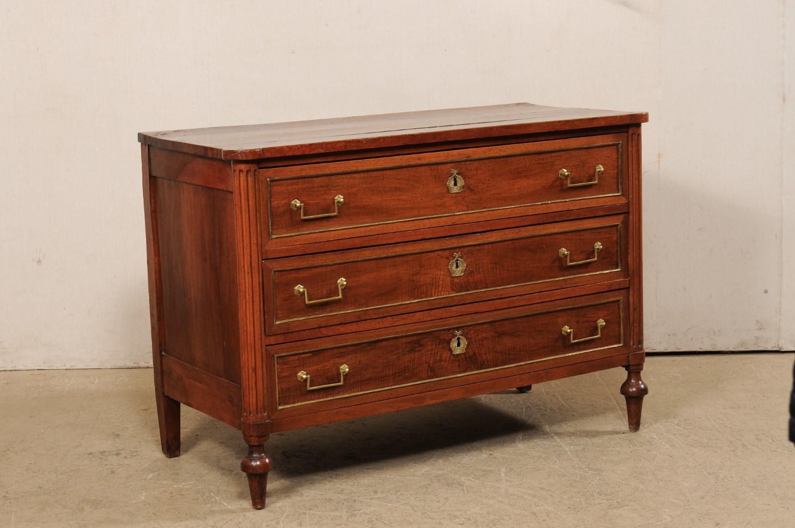 A French Neoclassical commode, with hidden secretary and original hardware, from the turn of the 18th and 19th century. This antique commode from France gives the appearance of being a three drawer chest at first glance. However, discreetly hidden