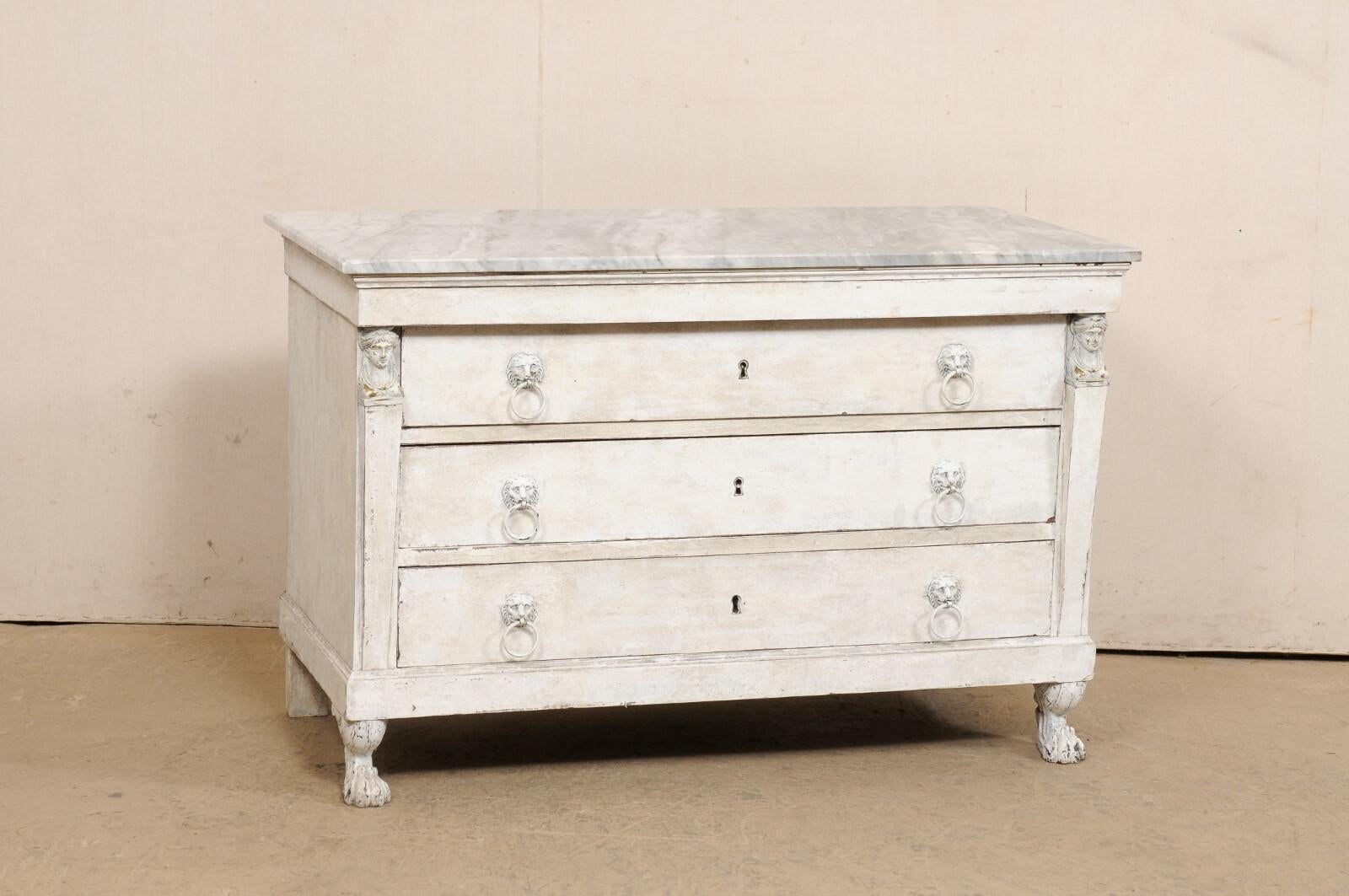 A French Neoclassic painted wood commode with marble top from the early 19th century. This antique chest from France features a rectangular-shaped white/gray marble top, above a case designed with clean lines and column-style side posts flanking the