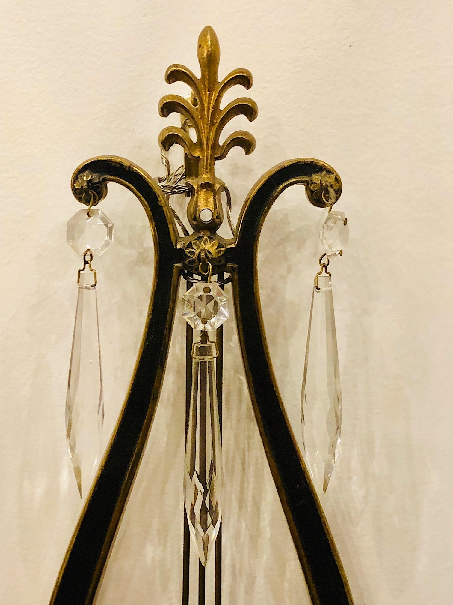 A pair of circa 1920's gilt and painted bronze lyre-shaped sconces with crystal drops.

Measurements:
Height 17