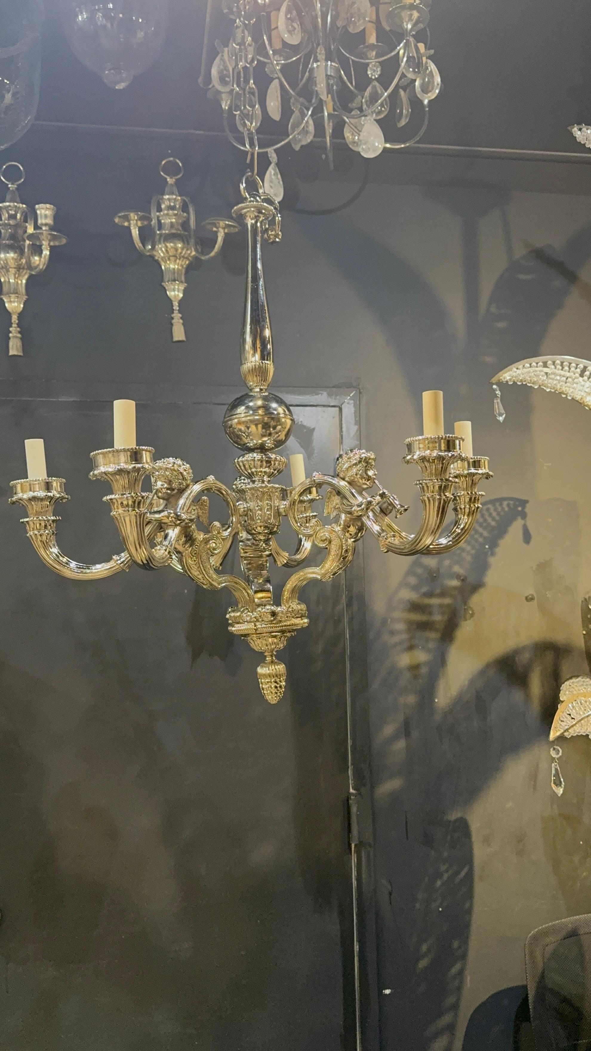 A beautiful neoclassical style chandelier with cherubs holding trumpets.