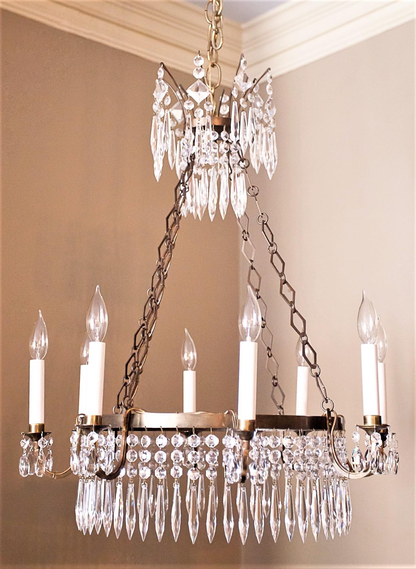 This 8-arm fixture has an original mirror plate bottom which give the fixture a distinctive look. Chandelier has hand-cast brass frame with handcut lead crystal prisms. May be shortened if desired. Ceiling cap, hanging hardware and one foot of chain