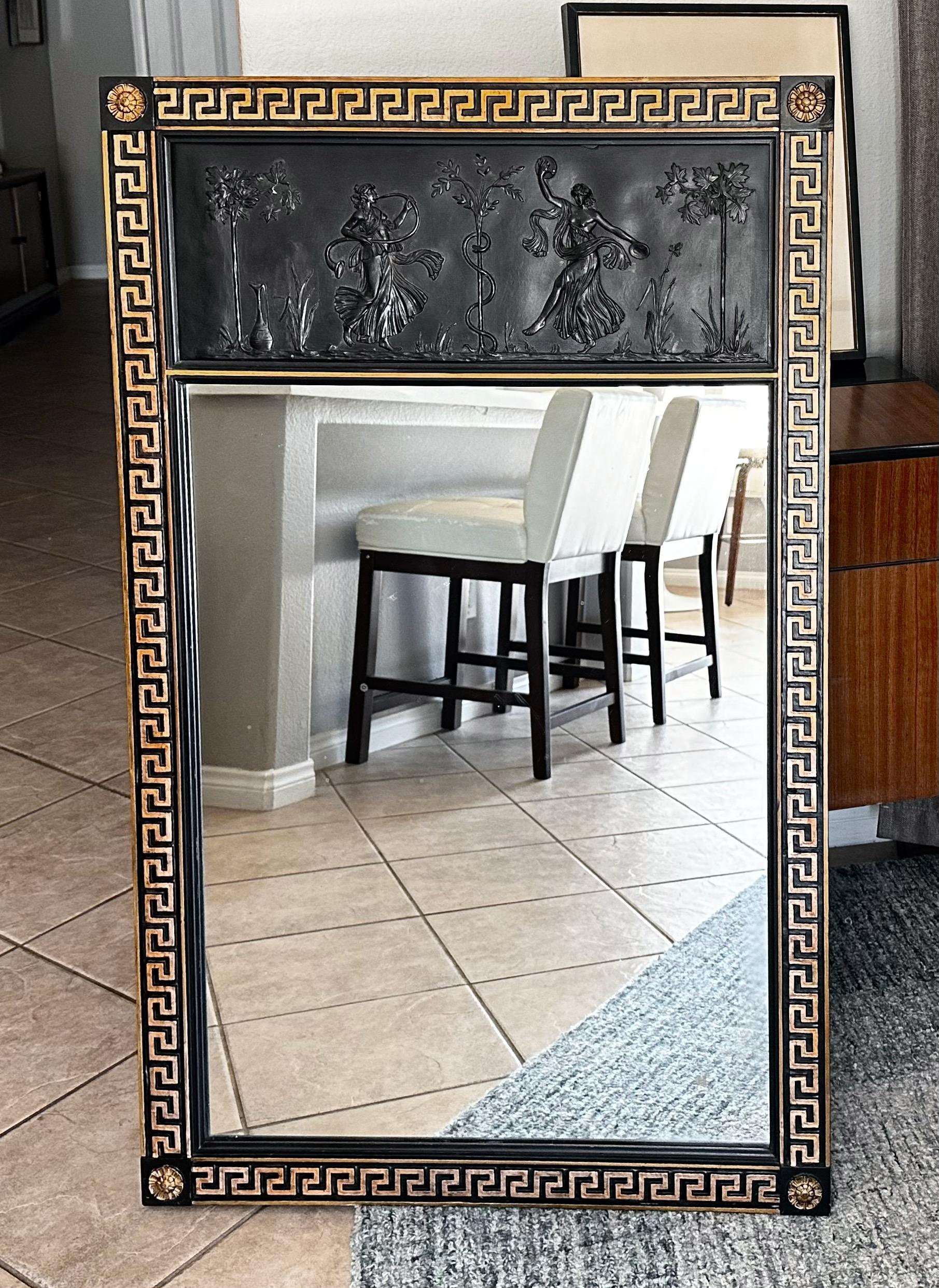 Miroir mural en bois laqué noir de style néo-classique. Elle est ornée d'une bordure décorative en forme de clé grecque sculptée en or et d'un relief figuratif néoclassique finement détaillé. 


