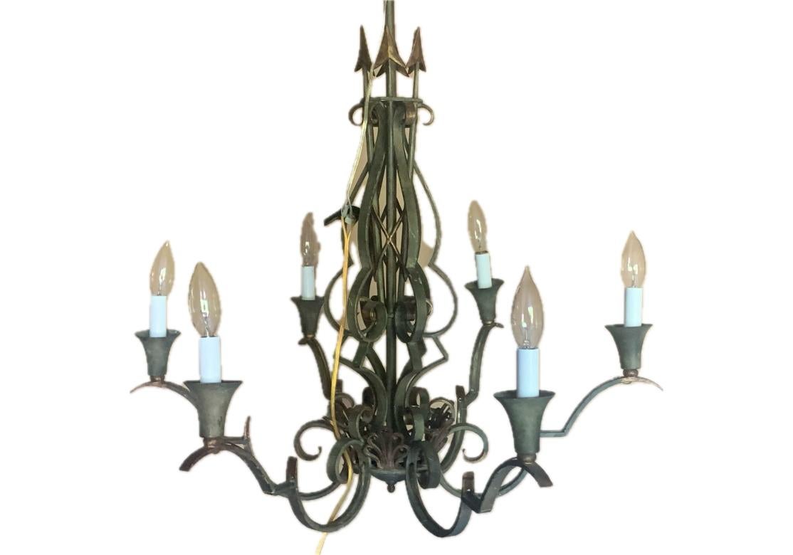 Vintage 6 light wrought iron chandelier with the arms bearing conical form bobeche and the standard in the form of a cluster of arrows. The chandelier with light hues of gold embellishments.

Dimensions:  26 1/2