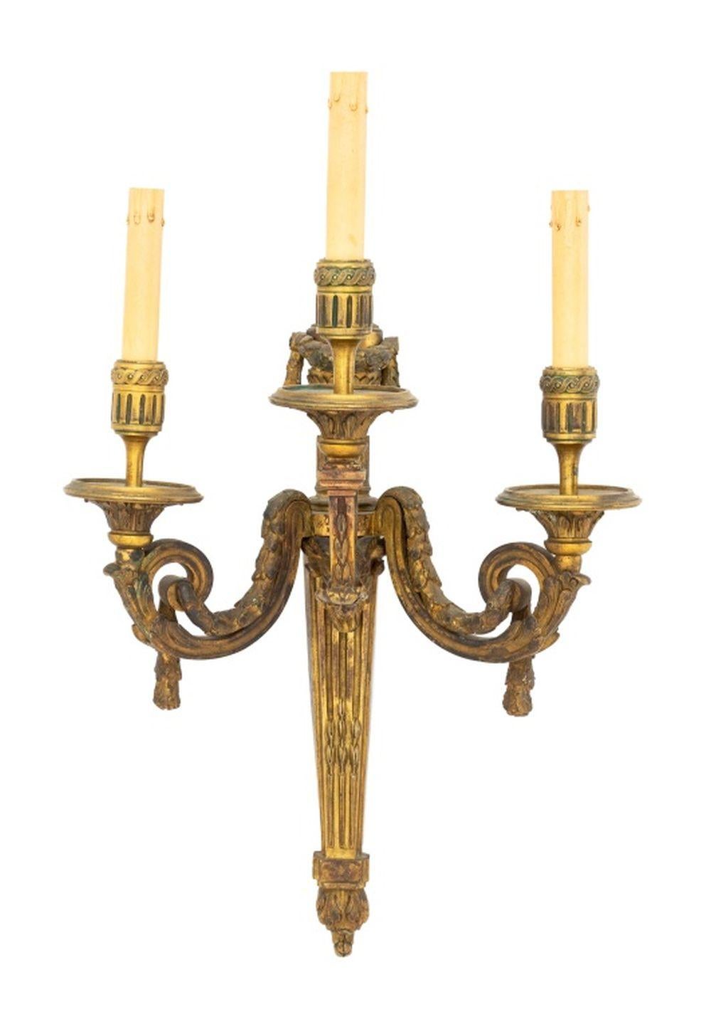 Coppia di appliques in bronzo dorato a tre rami in stile neoclassico, con mascherina a testa di capra e terminali a urna infuocata. 22