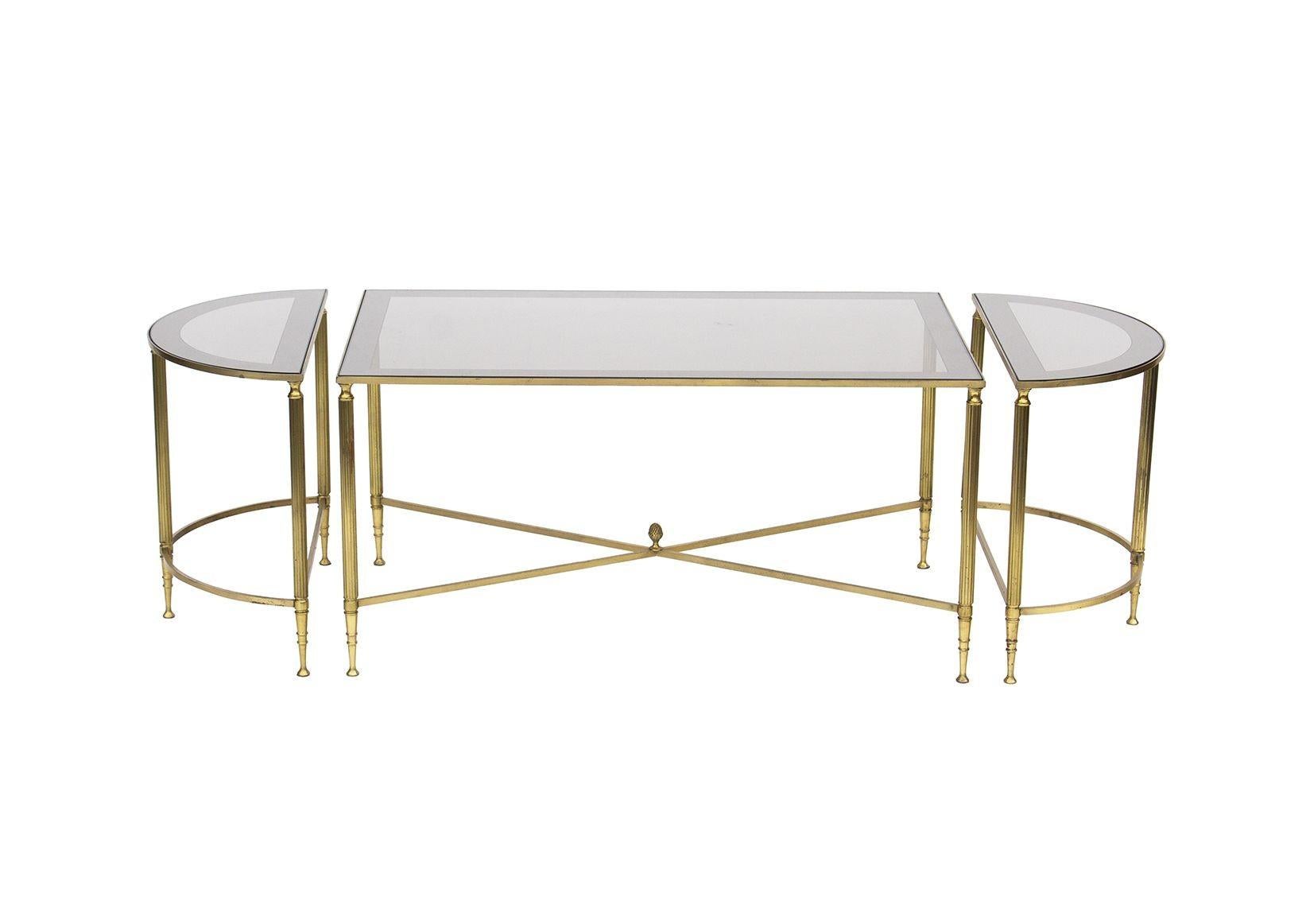 Italy, 1960s
 
Neoclassical 3 piece bunching cocktail table in brass after Maison Jansen. Elegant fluted legs. This set of three can be used together or separated as desired. The tops are original glass and reverse painted with a border around their