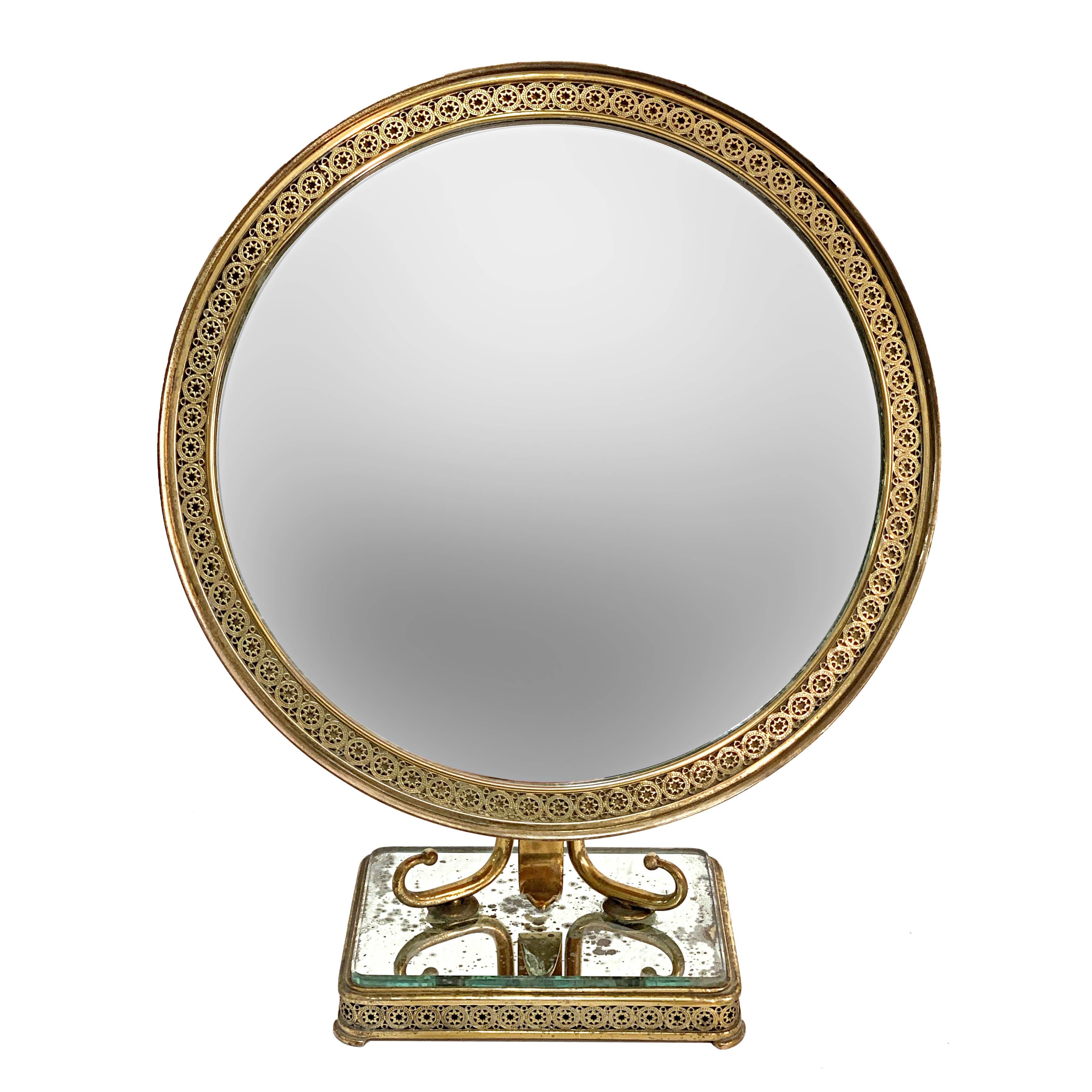 Wonderful neoclassical brass and wood Italian vanity table mirror.

This elegant table or make up mirror was designed and manufactured in Italy in the 1950s. The mirror has a solid two-column brass structure and a wooden base.

This item is the