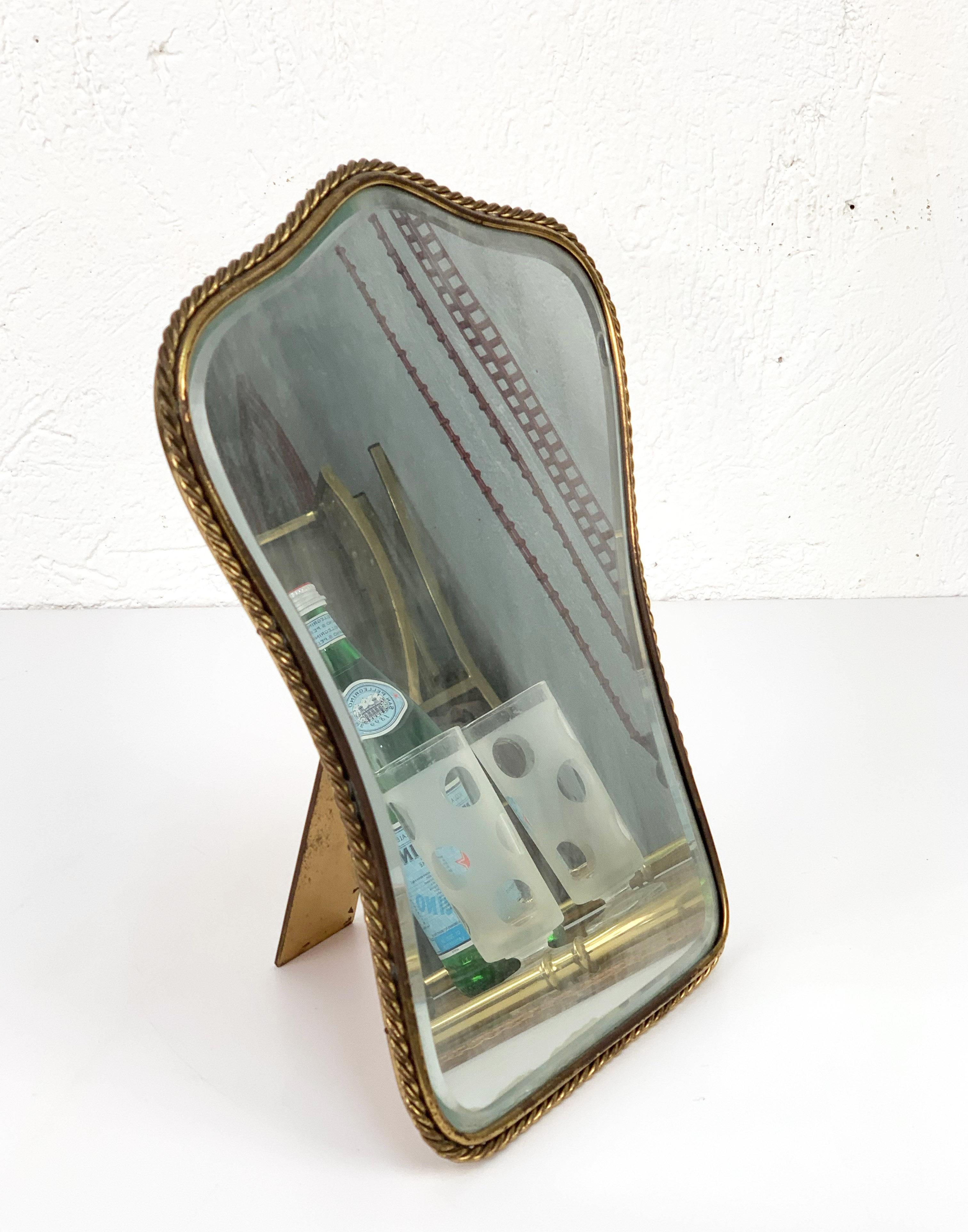 Wonderful neoclassical brass and wood Italian vanity table mirror.

This elegant table or makeup mirror was designed and manufactured in Italy in the 1950s. The mirror has a solid brass stand and a marvellous handmade frame.

This item suits