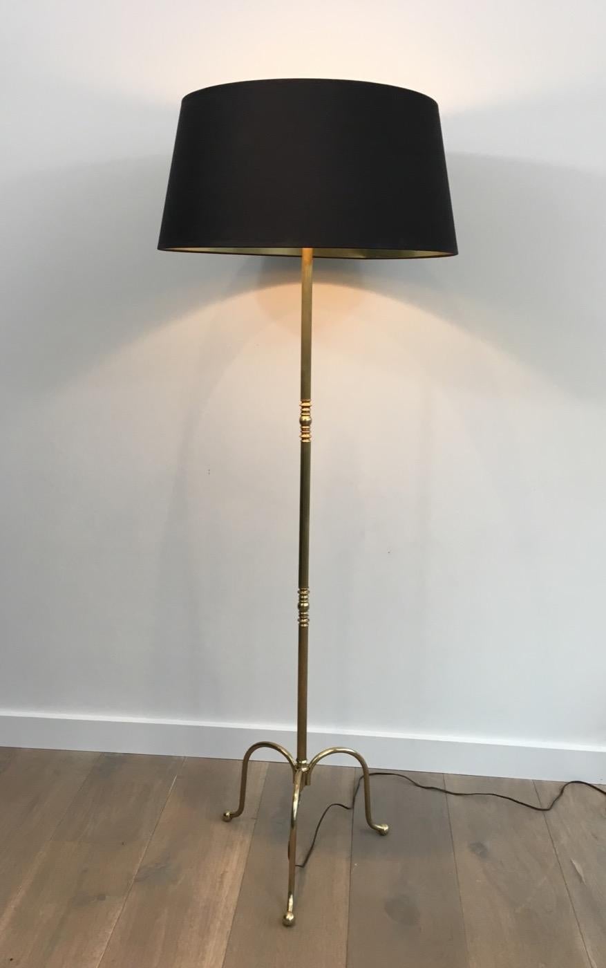 In the style of Maison Jansen. Neoclassical adjustable brass floor lamp with black shade gold inside. French, circa 1940.
 