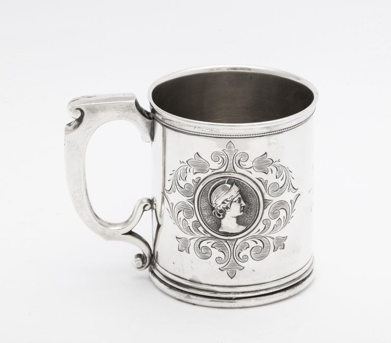 Neoclassical, American coin silver (.900) Medallion mug/cup, Ca. 1840's-1850's. Neoclassical image of a man is on one side of the mug; a Neoclassical image of a woman is on the other side. Cartouche has a lovely script inscription: BK from AK.