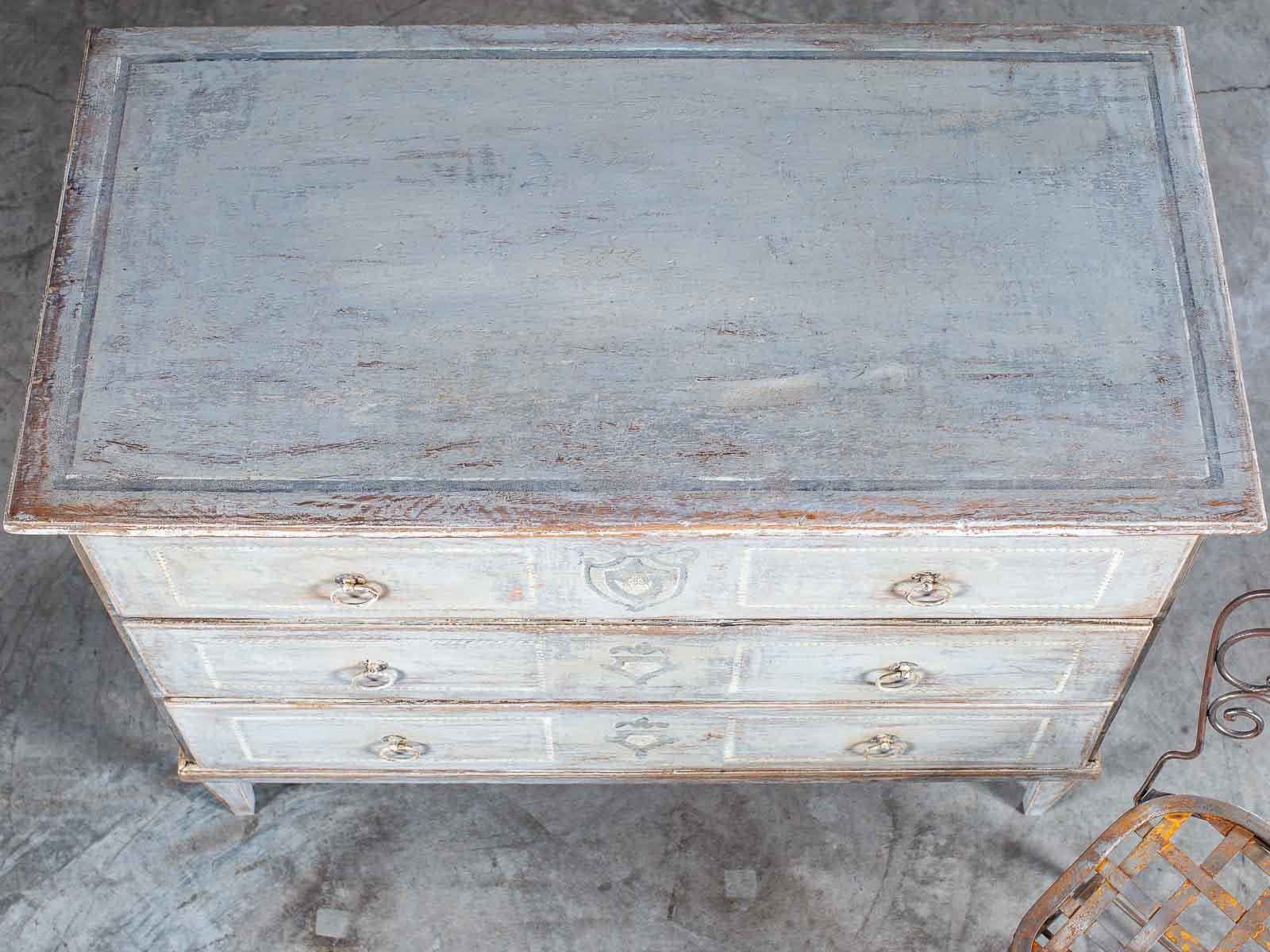 The clean and simple lines of this antique Austrian painted chest of drawers circa 1830 relate to the neoclassical style in vogue at the end of the 18th century. This antique chest has three drawers all the same size with a rounded edge that lays