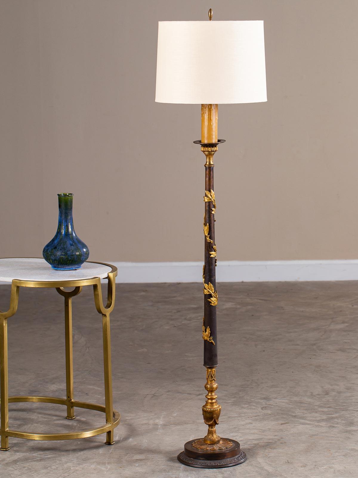 An elegant neoclassical antique French bronze and gilt bronze floor lamp, circa 1900 now wired for American electricity. The marvelous circular bronze base supports a symmetrical vase adorned with draped beads in gilt bronze which then supports a