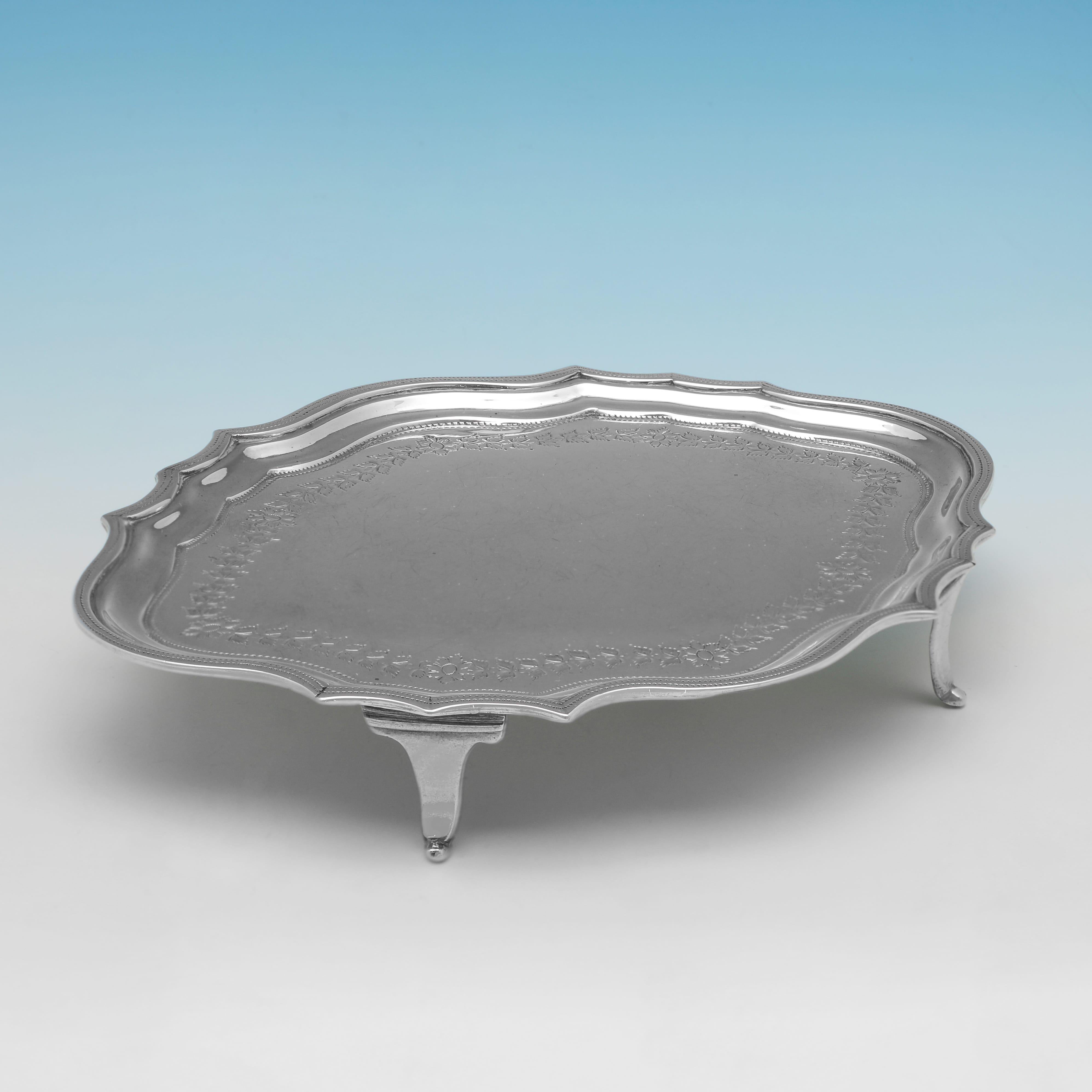 Hallmarked in London in 1802 by William Bennett, this handsome, Antique Sterling Silver Teapot Stand, is Neoclassical in design, and features a shaped oval border, and engraved decoration. The teapot stand measures 1.25
