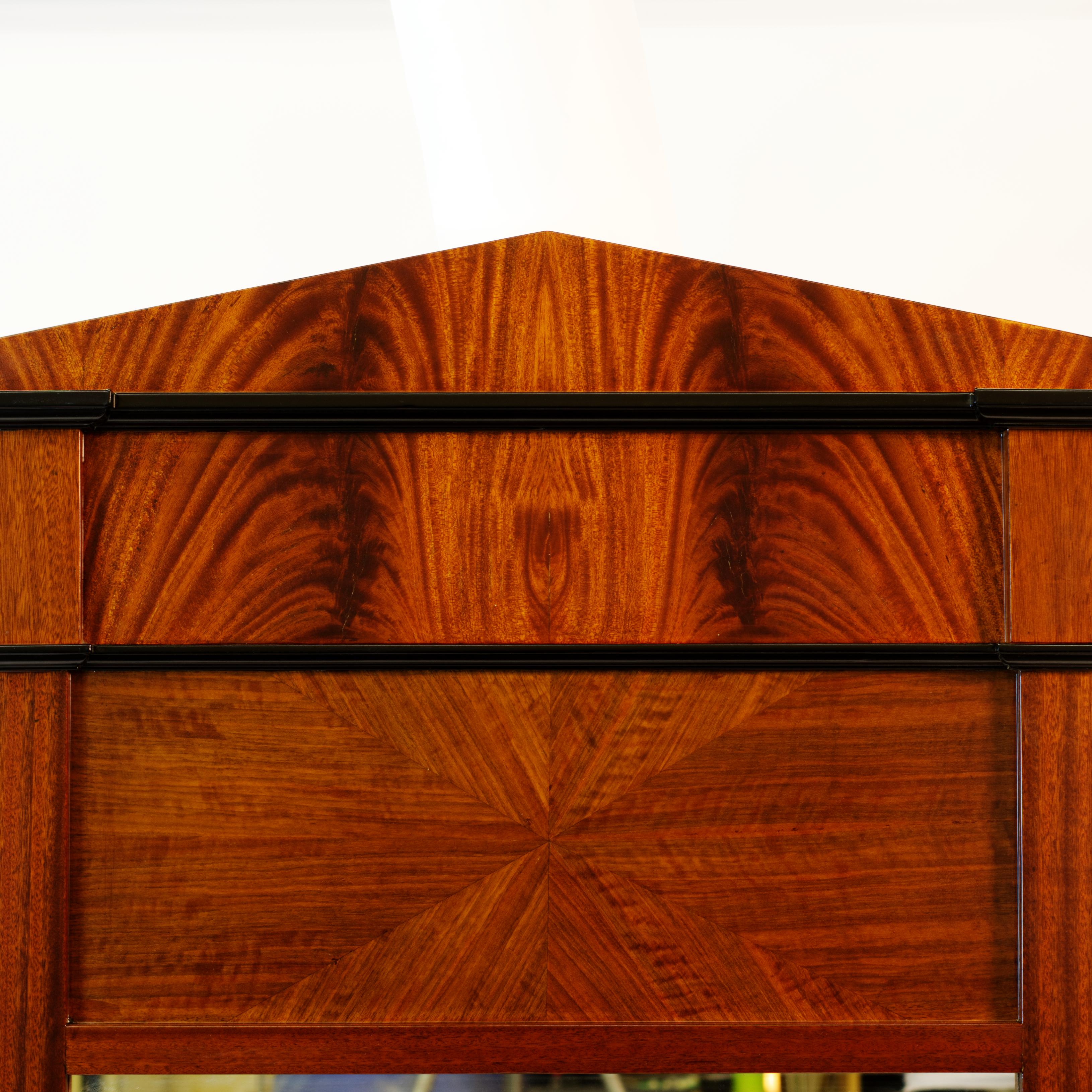 This mirror was inspired by various Biedermeier examples, featuring strong contrasting veneer work and exotic solids. Mahogany frame is accentuated by crotch mahogany veneer. Insert panels are sunburst figured walnut veneer. The mirror is finished