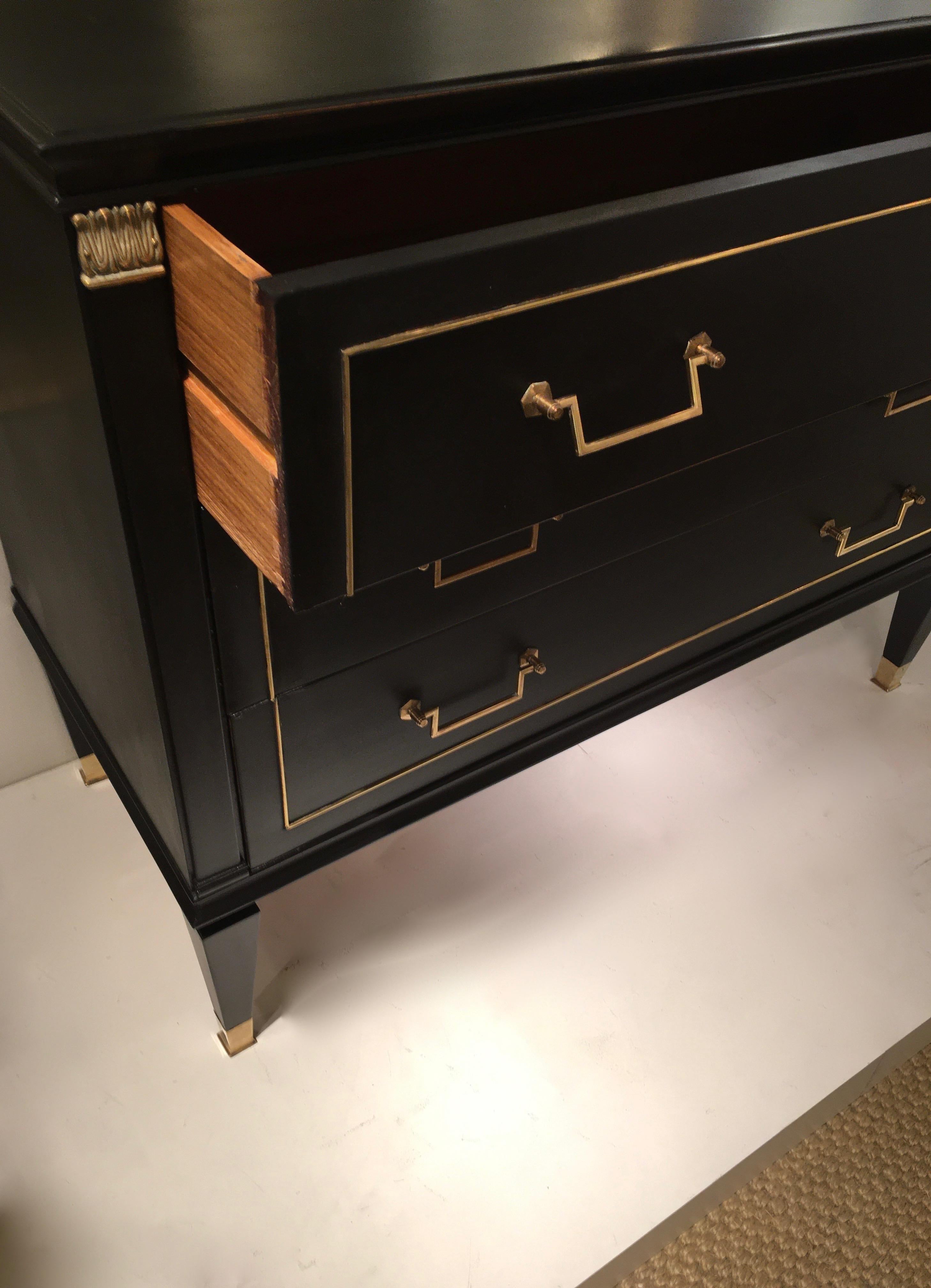 Fine chest of drawers with brass details, Louis XVI style.
Black lacquer, three drawers, elegant neoclassical feet with brass sabots.
By Jacques Quinet, France, 1948.