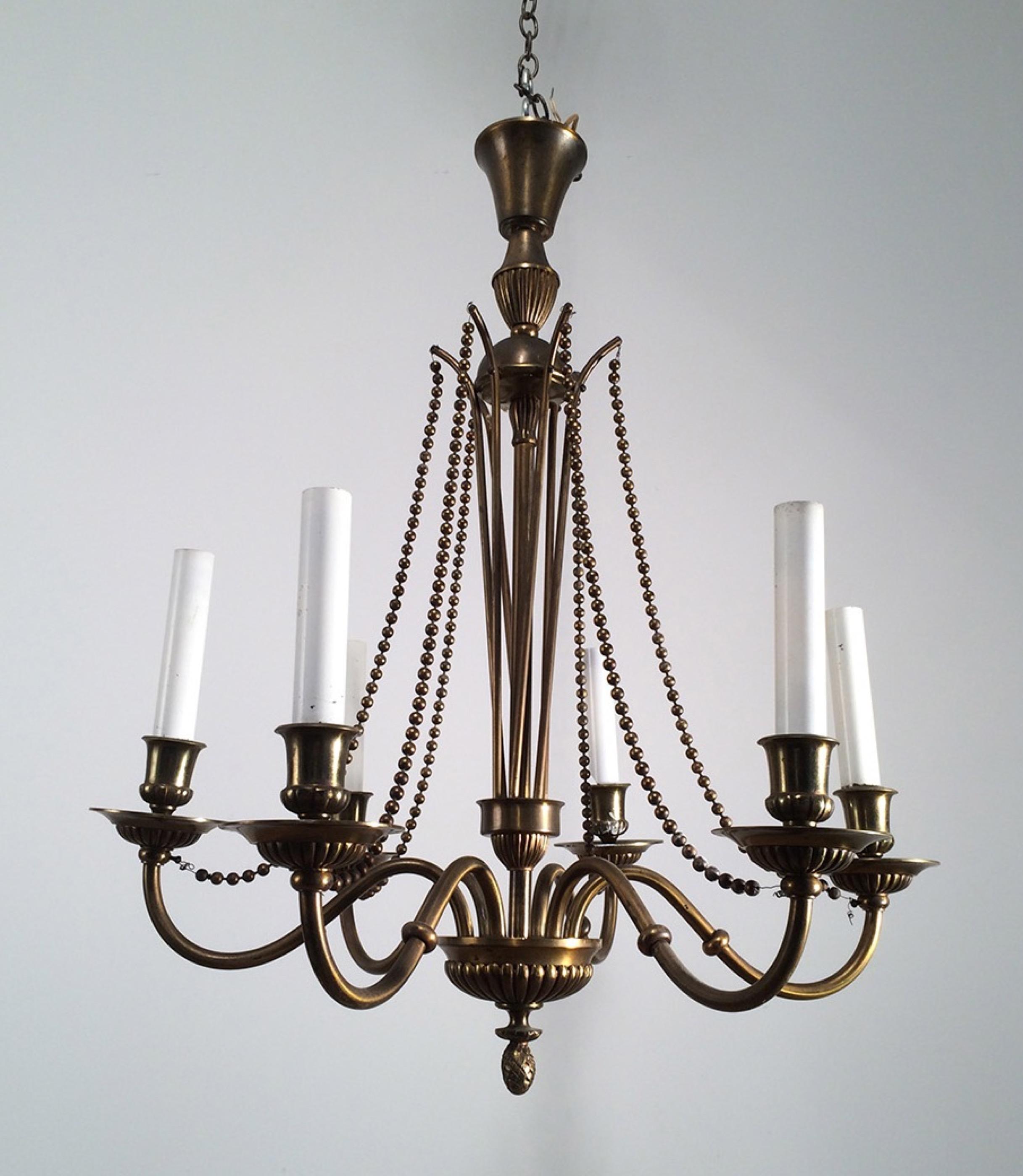 This neoclassical chandelier is made of brass and bronze. This is a very simple and very chic fixture. This is a French work, circa 1940.