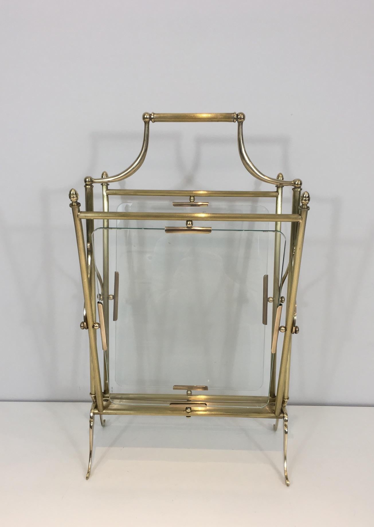 This neoclassical magazine rack is made of brass with a glass panel on each side. This piece is French and made of a nice quality and is attributed to Maison Jansen, circa 1940.
