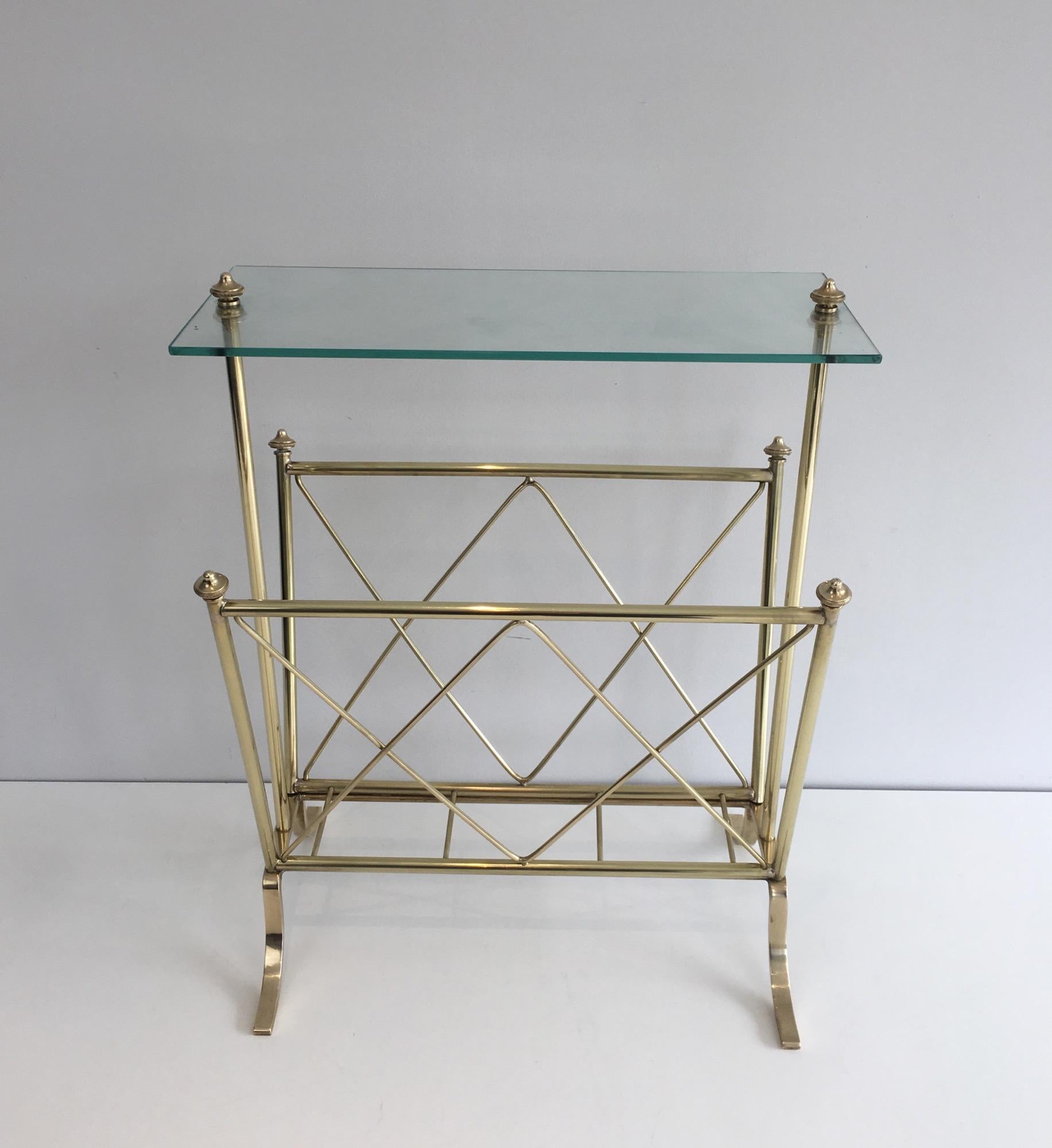 Questo simpatico ed elegante portariviste in stile neoclassico è realizzato in ottone con un piano in vetro. Si tratta di un'opera francese del famoso designer Maison Jansen. Circa 1940