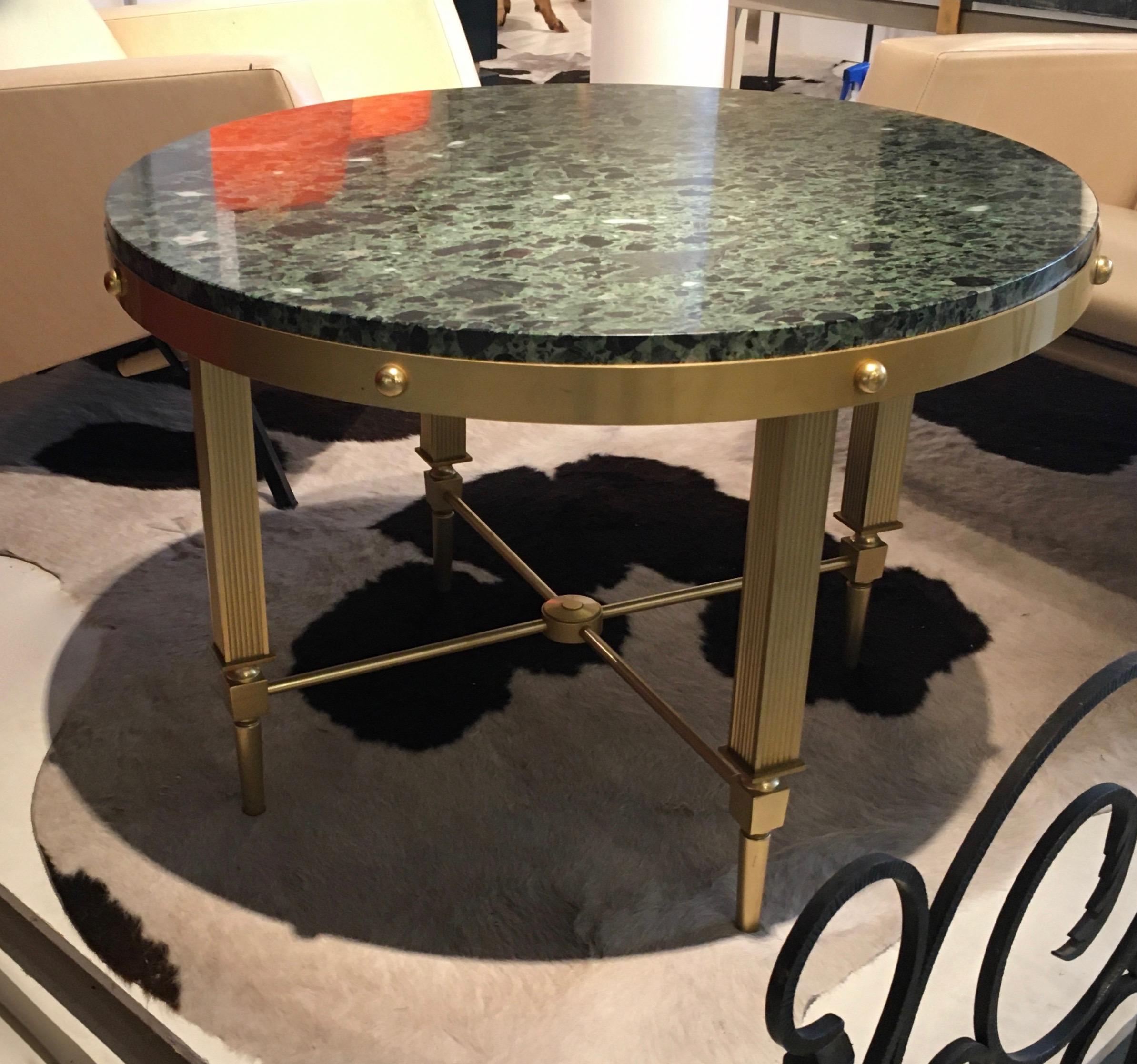 Elegant circular brass coffee table with a green marble top.
Design by Maxime Old.
France, around 1955.